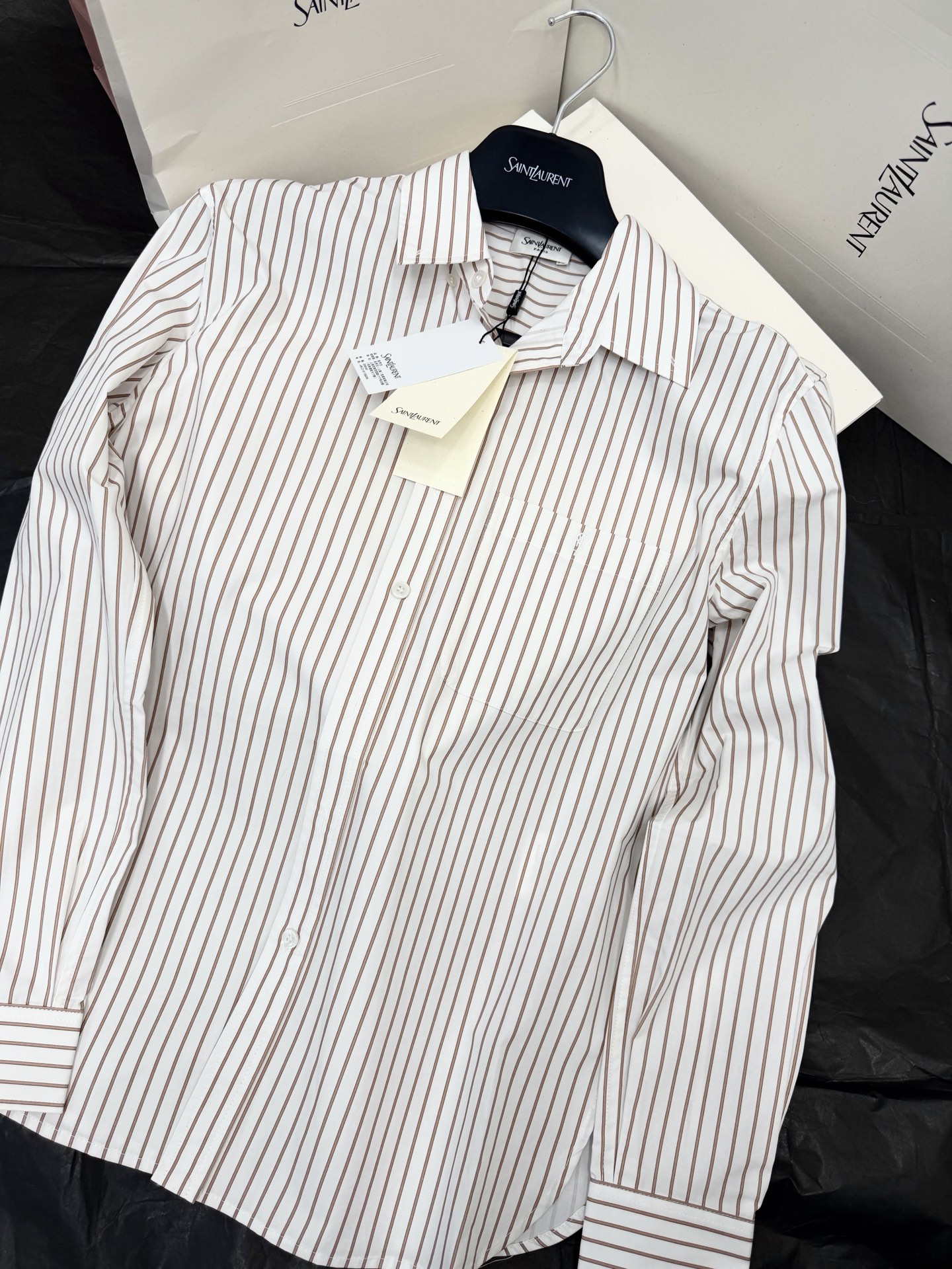 NO:807216,Original development~~ YSL striped shirt with white bottom and fine vertical stripes, simple and classic, lapel + single-breasted design, neat tailoring, adjustable cuffs, perfect details. High-quality cotton material, soft and breathable, super comfortable to wear in spring and autumn. Whether commuting or casual, it is OK to match with trousers, jeans or skirts, easy to switch between multiple styles, it is a must-have and versatile item in the wardrobe!  SML detailed pictures, saint laurent,skirts,jeans,shirts,19860909原版开发～～ YSL条纹衬衫白底配细密竖条纹,简约又经典,翻领+单排扣设计,剪裁利落,袖口可调节,细节满分.高品质棉料,柔软透气,春秋穿超舒服.无论通勤还是休闲,搭配西裤、牛仔裤或半裙都很OK,轻松切换多种风格,是衣橱必备百搭单品！SML 细节图实拍,,saint laurent,skirts,jeans,shirts,,Women's clothing