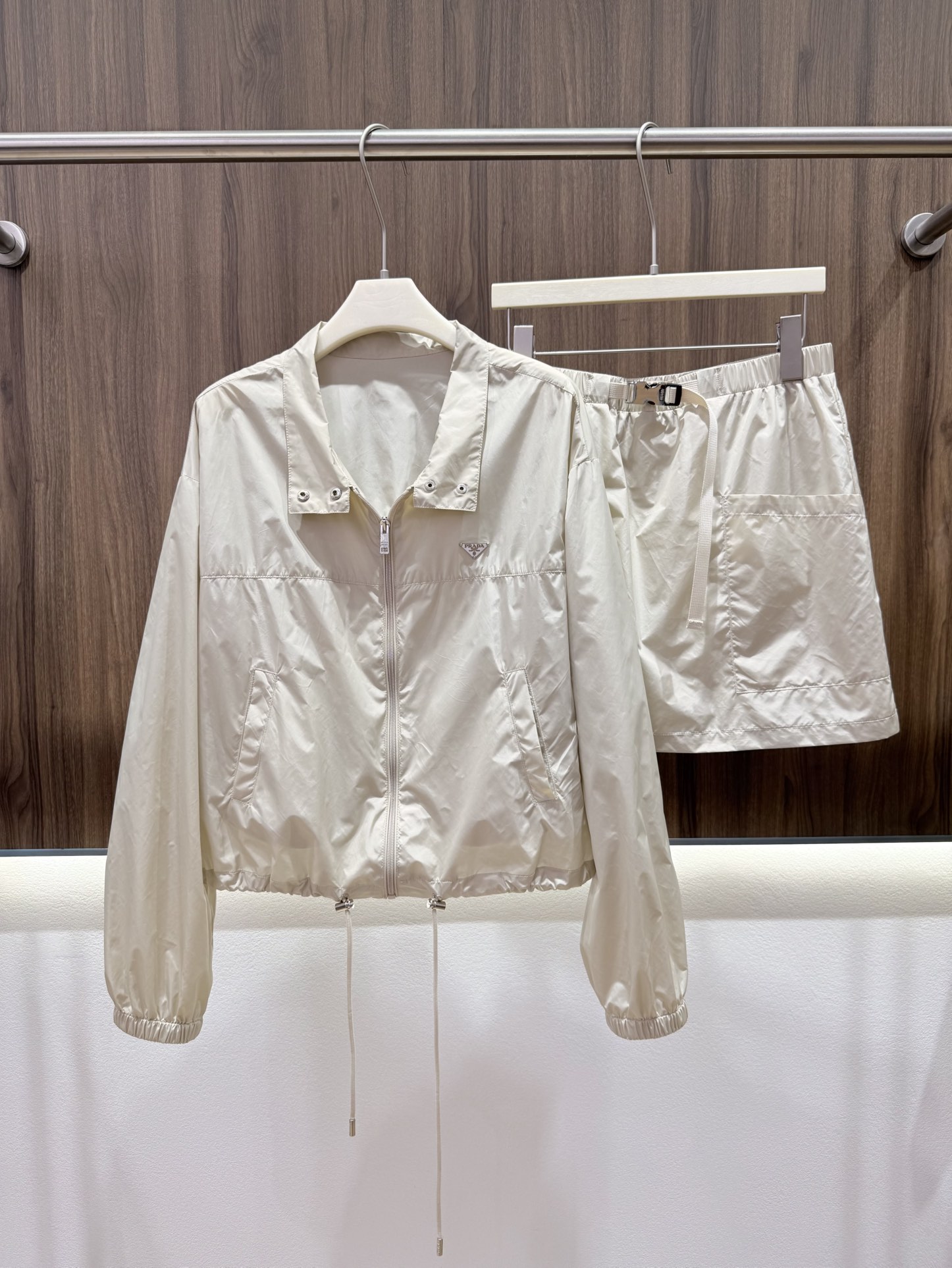 NO:807751,2026 summer Prada sun protection suit. Simple stand-up collar, windproof and sun protection. Smooth zipper opening and closing. Triangular metal logo embellishment. Exquisite, small and low-key. The drawstring at the hem can be freely adjusted. Casual elasticity. Paired with the same series of webbing skirts. The upper body covers the flesh and looks slimmer. Exclusively customized sun protection fabric with low saturated and gentle tones. It can be worn alone as a complete set, high-end and simple. Split and mix. One outfit for multiple wear. Easy to choose a refreshing Korean relaxed style in summer.  Three-color SML,,skirts,198609092026夏季普la达防晒套装 简约立领防风防晒 顺滑拉链开合 三角金属logo点缀 精致小巧低调 下摆抽绳可自由调节 随性松紧收 搭配同系列织带半裙 上身遮肉显瘦 独家定制防晒面料低饱和温柔色调 单穿成套高级简约亦可 拆分混搭 一衣多穿 轻松拿捏夏日清爽韩系松弛穿搭 三色SML,,skirts,,Women's clothing