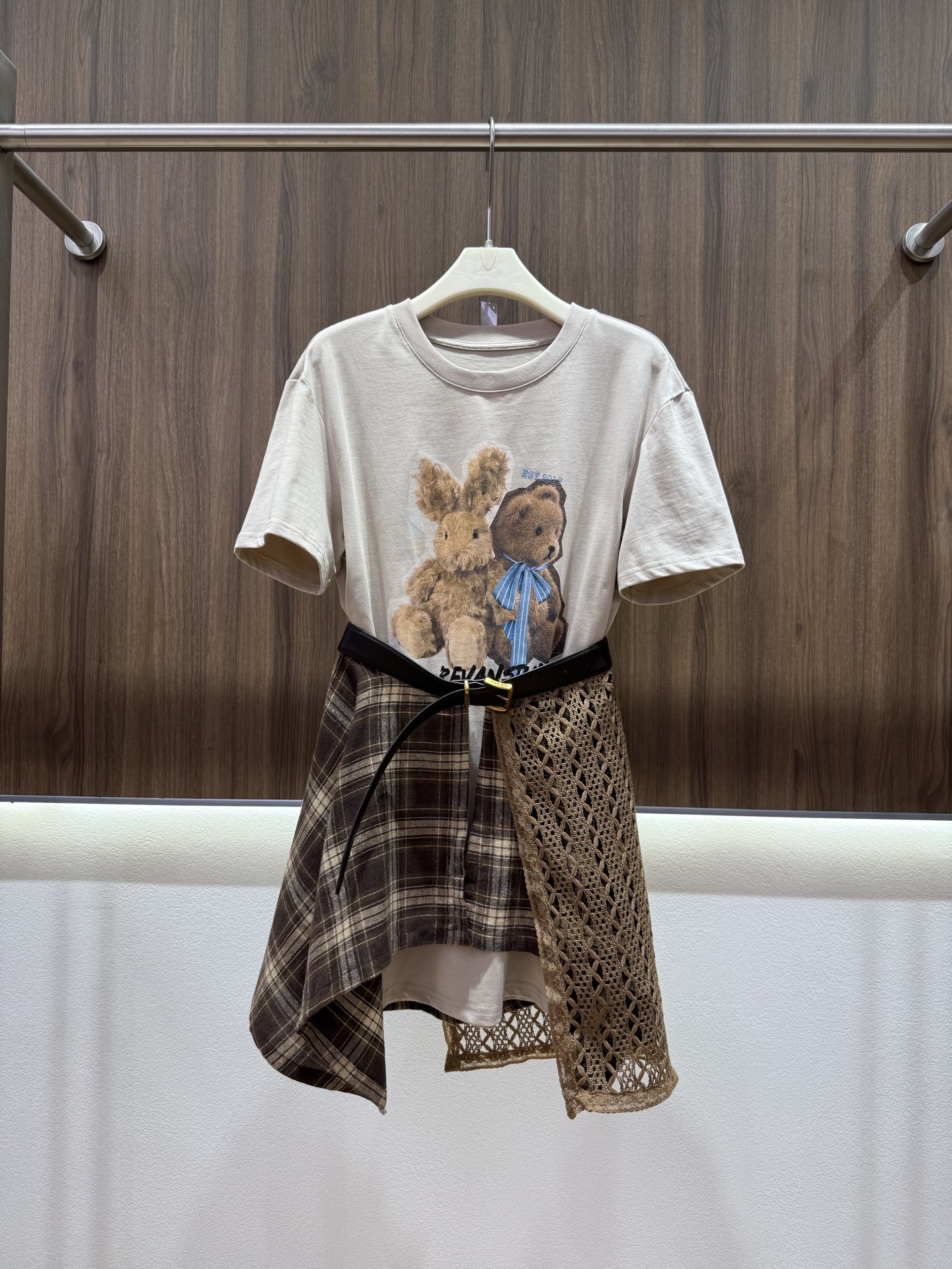 NO:952210,Autumn 2026 re'van two-piece T-skirt, doll bear T-skirt + spliced plaid curtain suit, soft and waxy light khaki short sleeves, retro bunny bear print, self-layered plaid hollow curtain, matching belt, a complete set that can be easily worn without having to worry about matching. The irregular hem cleverly modifies the body shape. Sweet and cool Korean atmosphere. Wear a T-shirt skirt alone or wear it as a complete set. You can switch between the two styles at will.  Monochrome SML,,skirts,T-shirt,tees,t-shirt,198609092026秋 re'van两件套T裙 玩偶小熊T裙+拼接格纹披帘套装 软糯浅卡其短袖 复古兔子小熊印花 自带层次感格纹镂空围帘 搭配腰带 一整套轻松穿出层次感 不用费心搭配 不规则下摆巧妙修饰身形 甜酷韩系氛围感 单穿T恤裙或整套穿搭两种风格随心切换 单色SML,,skirts,T-shirt,tees，t-shirt,,Women's clothing