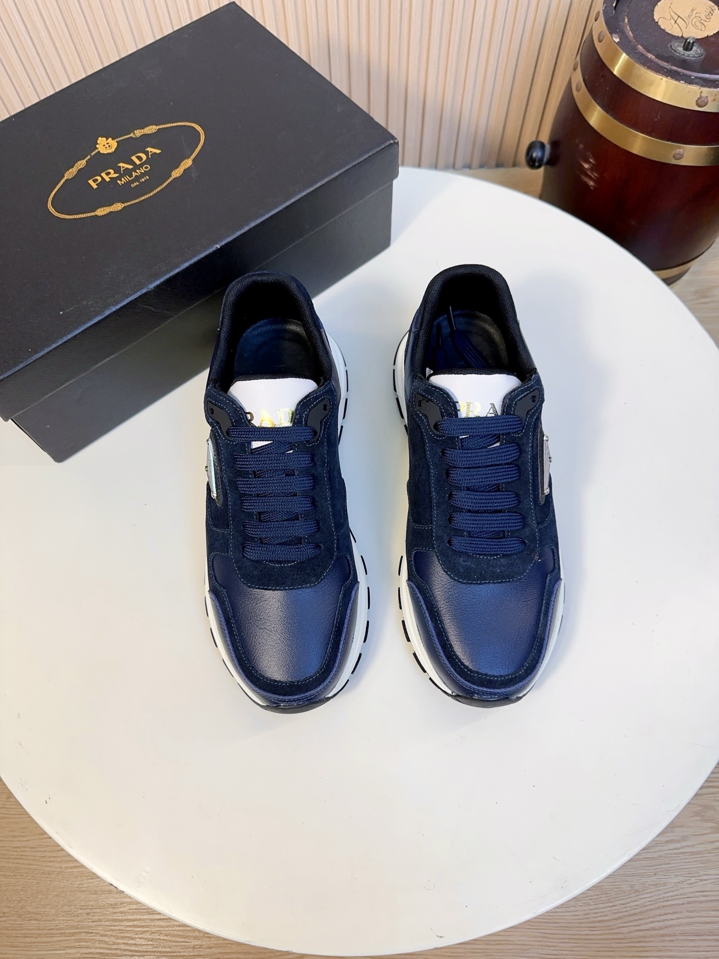 NO:834029,Prada is a top luxury brand founded in Milan, Italy in 1913. It subverts traditional avant-garde designs and is recognized as a 'style definer' in the fashion industry. Prada's shoe series, especially sports shoes, has always been the benchmark in the high-end casual shoe market.  The upper ~ leather part is made of first-layer calfskin imported from Italy. It has been processed by the brand's exclusive tanning process. The leather surface is fine and shiny, has high flexibility, is not easy to wrinkle and crack, and can maintain the firm shape of the shoe even after long-term wear. It has a high-grade touch and is skin-friendly and does not rub the feet.  The suede-stitched shoe body is paired with suede cowhide (suede), with a fine and matte texture, which enhances the retro texture of the shoe. At the same time, it forms a material contrast with the smooth leather. It is rich in layers and will not feel stuffy when worn in summer. It also echoes Prada's brand genes.  The entire shoe is made of skin-friendly sheepskin lining, which is soft to the touch, reduces friction when wearing, and improves overall durability. The brand-customized cushioning sheepskin insole, with the Prada logo, is soft and supportive, which can effectively relieve foot fatigue after long walks, and is removable for easy cleaning and care.  The sole has a slight heightening effect (approximately 3-4cm), which has both lightweight and cushioning properties. It can be worn for a long time without tiring the feet. The non-slip and wear-resistant rubber outsole has the Prada embossed logo and anti-slip texture. It has strong grip and can provide stable support in rainy days or slippery roads. The wear resistance can also meet the needs of daily commuting and short-distance travel.  38-44,A9,,prada,prada,sneakers,cowhide,sheepskin,chamois leather19860909Prada（普拉达）是1913年创立于意大利米兰的顶级奢侈品牌,以颠覆传统的先锋设计,是时尚界公认的“风格定义者”.Prada的鞋履系列,尤其是运动鞋,一直是高端休闲鞋市场的标杆. 鞋面～皮革部分采用意大利进口头层小牛皮,经过品牌专属鞣制工艺处理,皮面细腻有光泽,柔韧度高,不易起皱、开裂,长期穿着也能保持鞋型挺括,触感高级且亲肤不磨脚. 翻毛拼接鞋身搭配反绒牛皮（麂皮）,质感细腻哑光,提升鞋款的复古质感,同时和光面皮革形成材质对比,层次丰富,夏天穿着不闷脚,同时呼应了Prada的品牌基因. 全鞋采用亲肤羊皮内里,触感柔软,减少穿着时的摩擦感,同时提升整体的耐用性.品牌定制的缓震羊皮鞋垫,带有Prada标识,柔软有支撑,能有效缓解久走的足部疲劳,且可拆卸设计方便清洁打理. 鞋底自带轻微增高效果（约3-4cm）,兼具轻量化和缓震性能,久穿不累脚,防滑耐磨橡胶大底,带有Prada压花徽标和防滑纹路,抓地力强,无论是雨天还是湿滑路面都能提供稳定支撑,耐磨性也能满足日常通勤、短途出行的需求. 38-44,A9,,prada,prada,sneakers,cowhide,sheepskin,chamois leather,Men's shoes