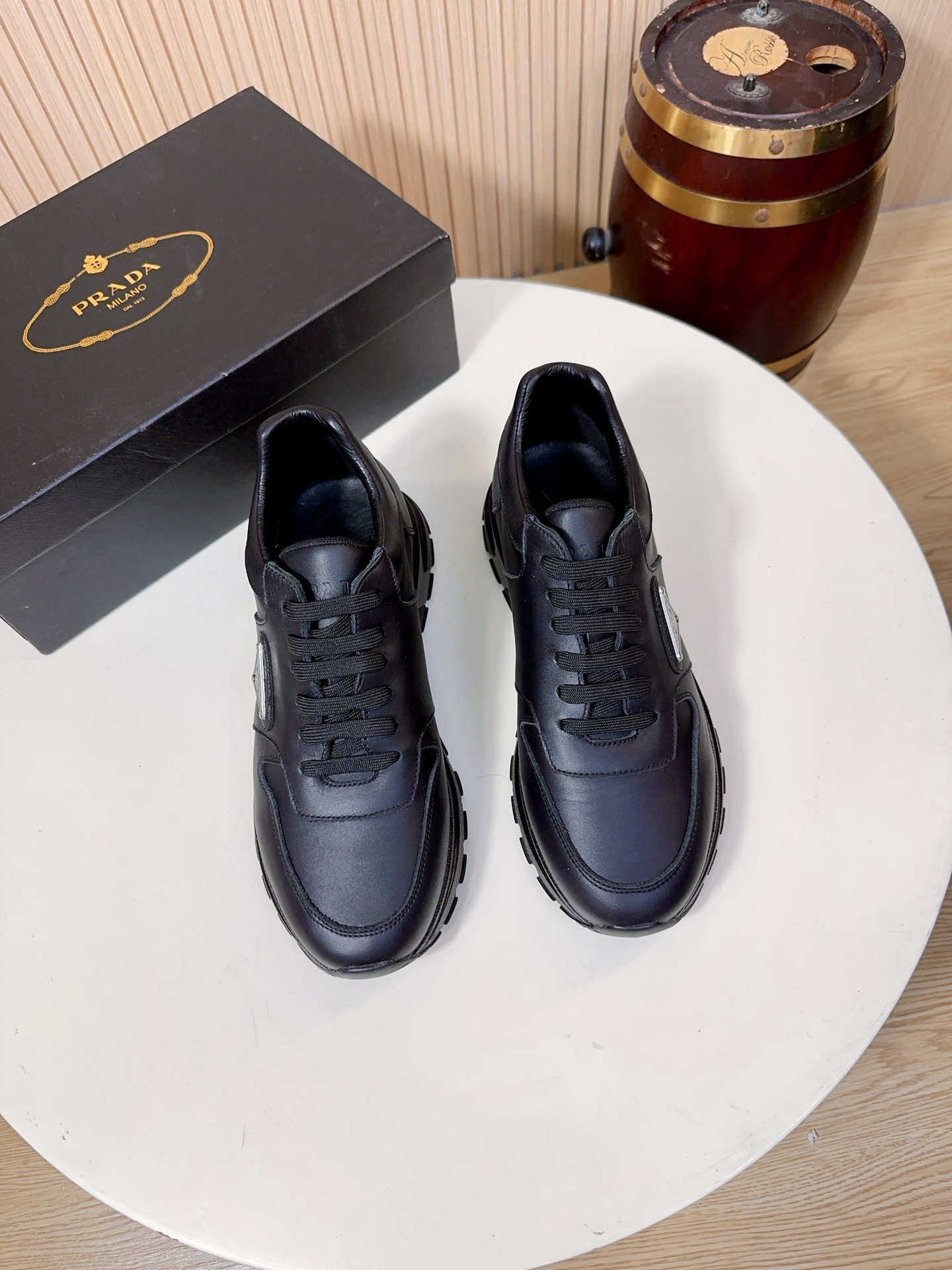 NO:833974,Prada is a top luxury brand founded in Milan, Italy in 1913. It subverts traditional avant-garde designs and is recognized as a 'style definer' in the fashion industry. Prada's shoe series, especially sports shoes, has always been the benchmark in the high-end casual shoe market. (Shoes  Surface material (top layer cowhide + suede cowhide) The main body of the shoe is made of imported first layer calfskin (Napa cowhide), which has a delicate and soft touch, strong toughness, and is not easy to deform and crack. It can maintain the shape of the shoe even after long-term wear. It has a high-grade matte/soft light texture and is a standard material for high-end shoes of luxury brands.  The side and heel of the white model are made of imported first-layer suede cowhide, which has a soft touch and a matte high-end texture. It not only enriches the layering of the shoe body, but also improves the wear resistance of the shoe side and neutralizes the monotony of the full leather surface.  The lining and insole are the standard features of Prada's high-end shoes. The lining is mostly lambskin/first-layer cowhide, which is soft against the skin and does not rub the feet. The tongue and mouth of the shoe are also thickened; the insole has the Prada hot-stamped logo, and some styles use memory foam + genuine leather foot pads. While cushioning and rebounding, it can fit the shape of the foot, and the feet will not be tired after walking for a long time.  The soles are made of Prada's customized non-slip rubber material, with the brand's iconic anti-slip texture design, which has strong grip and is not easy to slip on rainy days. It has been lightweighted, with a single shoe weighing only about 300g, which greatly reduces the burden on the feet. The midsole has a cushioning structure, which combines support and comfort, and is suitable for daily commuting and short-distance travel. 38-44, A9,, prada, prada, sneakers, cowhide, sheepskin19860909Prada（普拉达）是1913年创立于意大利米兰的顶级奢侈品牌,以颠覆传统的先锋设计,是时尚界公认的“风格定义者”.Prada的鞋履系列,尤其是运动鞋,一直是高端休闲鞋市场的标杆.（鞋面材质头层牛皮+反绒牛皮双拼）鞋身主体采用进口头层小牛皮（纳帕牛皮）,触感细腻柔软、韧性强,不易变形开裂,长期穿着也能保持鞋型挺括,自带高级哑光/柔光质感,是奢侈品牌高端鞋履的标配材质. 白色款的鞋侧、后跟部分采用进口头层反绒牛皮,触感柔和,自带哑光高级质感,既丰富了鞋身的层次感,也提升了鞋侧的耐磨性,中和了全皮面的单调感. 内里与鞋垫Prada高端线鞋款的标配,内里多为羔羊皮/头层牛皮,贴肤穿着柔软不磨脚,鞋舌、鞋口处也做了加厚处理；鞋垫带有Prada烫印标识,部分款式采用记忆棉+真皮垫脚,缓震回弹的同时,能贴合脚型,长时间走路也不累脚. 鞋底采用Prada定制的防滑橡胶材质,带有品牌标志性的防滑纹路设计,抓地力强,雨天也不易打滑；做了轻量化处理,单只鞋重量仅约300g,大幅减轻脚部负担；中底带有缓震结构,兼顾了支撑性与舒适感,适合日常通勤与短途出行.38-44,A9,,prada,prada,sneakers,cowhide,sheepskin,Men's shoes