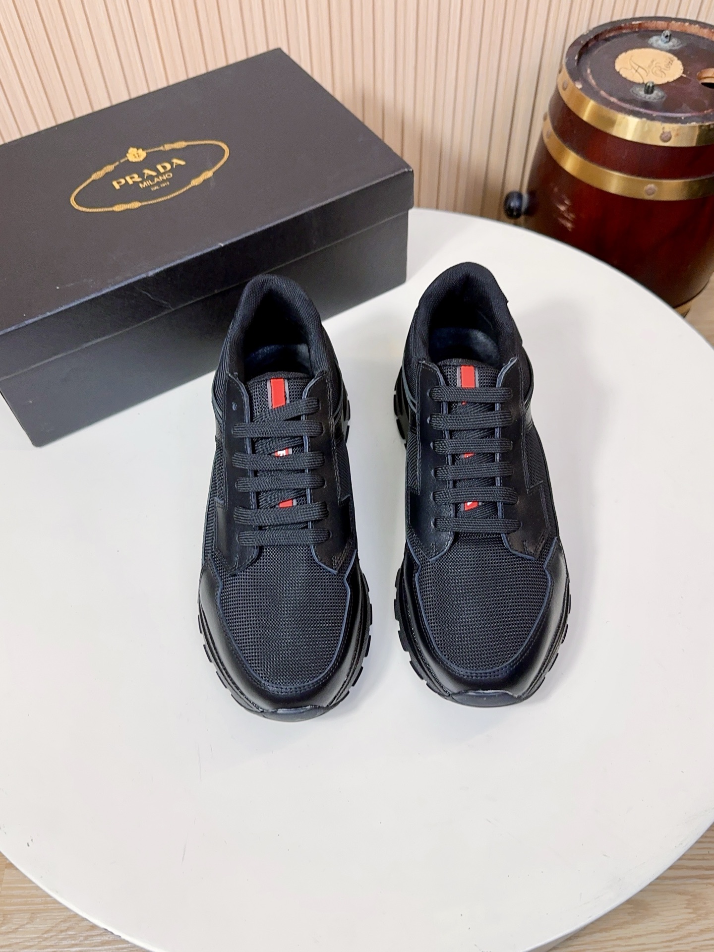 NO:833983,Prada is a top luxury brand founded in Milan, Italy in 1913. It subverts traditional avant-garde design and is recognized as a 'style definer' in the fashion industry. Prada's shoe series, especially sports shoes, has always been the benchmark for the high-end casual shoe market. (The upper material is Prada technical mesh + first-layer cowhide + brand iconic webbing) The shoe body is made of high-density breathable technical mesh (partly Prada  Re-Nylon (regenerated nylon) is a material that is lightweight, strong, and breathable. It is not easy to stuffy or deform, and is easy to take care of daily. It is one of the commonly used materials for Prada shoes. The first-layer cowhide is used to splice the toe and the leather area on the side of the shoe. It is made of imported first-layer calfskin, which has a delicate and soft touch, strong toughness, and is not easy to crack and deform. It can maintain the firm shape of the shoe even after long-term wear, and has a high-grade matte texture.  The brand's iconic webbing details on the tongue and the red/white/red webbing on the side of the shoe are one of Prada's classic design elements. They not only reflect the brand's recognition, but also add a touch of bright color to the overall low-key shoes, making the design more dynamic.  The lining and insole are standard features of Prada's high-end shoes. The lining is mostly made of lambskin, which is soft against the skin and does not rub the feet. The tongue and mouth of the shoe are also thickened; the insole has the Prada hot-stamped logo, and some styles use memory foam + genuine leather foot pads. While cushioning and rebounding, it can fit the shape of the foot, and the feet will not be tired after walking for a long time.  The soles are made of Prada's customized non-slip rubber material, with the brand's iconic anti-skid texture design, which has strong grip and is not easy to slip on rainy days. It has been lightweighted, with a single shoe weighing only about 300g, which greatly reduces the burden on the feet. The midsole has a cushioning structure, which combines support and comfort, and is suitable for daily commuting and short-distance travel. A38-44, A9,, prada, prada, sneakers, cowhide, sheepskin19860909Prada（普拉达）是1913年创立于意大利米兰的顶级奢侈品牌,以颠覆传统的先锋设计,是时尚界公认的“风格定义者”.Prada的鞋履系列,尤其是运动鞋,一直是高端休闲鞋市场的标杆.（鞋面材质Prada科技网布+头层牛皮+品牌标志性织带）鞋身采用高密透气科技网布（部分为Prada Re-Nylon再生尼龙）,这种材质兼具轻量化、强韧性与透气性,不易闷脚、不易变形,日常打理也很方便,是Prada鞋履的常用材质之一. 头层牛皮拼接鞋头、鞋侧的皮革区域,采用进口头层小牛皮,触感细腻柔软、韧性强,不易开裂变形,长期穿着也能保持鞋型挺括,自带高级哑光质感. 品牌标志性织带细节鞋舌、鞋侧的红/白/红织带,是Prada经典的设计元素之一,不仅是品牌辨识度的体现,也为整体偏低调的鞋款增添了一抹亮色,让设计更具活力. 内里与鞋垫Prada高端线鞋款的标配,内里多为羔羊皮,贴肤穿着柔软不磨脚,鞋舌、鞋口处也做了加厚处理；鞋垫带有Prada烫印标识,部分款式采用记忆棉+真皮垫脚,缓震回弹的同时,能贴合脚型,长时间走路也不累脚. 鞋底采用Prada定制的防滑橡胶材质,带有品牌标志性的防滑纹路设计,抓地力强,雨天也不易打滑；做了轻量化处理,单只鞋重量仅约300g,大幅减轻脚部负担；中底带有缓震结构,兼顾了支撑性与舒适感,适合日常通勤与短途出行.A38-44,A9,,prada,prada,sneakers,cowhide,sheepskin,Men's shoes