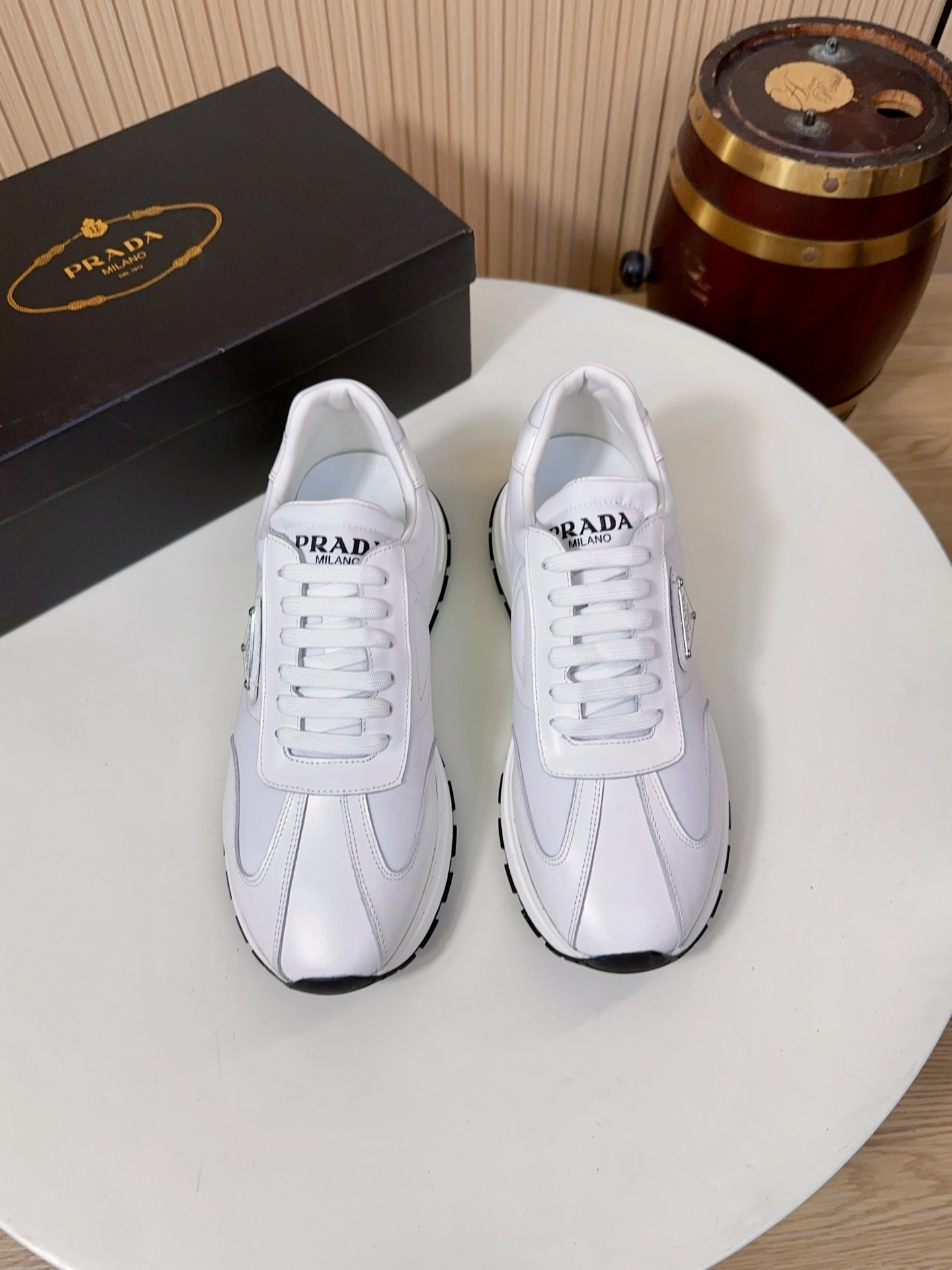 NO:833999,Prada is a top luxury brand founded in Milan, Italy in 1913. It subverts traditional avant-garde design and is recognized as a 'style definer' in the fashion industry. Prada's shoe series, especially sports shoes, has always been the benchmark for the high-end casual shoe market. (Upper material: Prada's iconic technical nylon + multi-material  Splicing) The main body of the shoe is made of Prada's iconic Re-high-density technical mesh). This material is Prada's trump card material. It is lightweight, strong, breathable, waterproof and stain-resistant, and not easy to deform. It solves the problems of traditional leather shoes being stuffy and difficult to care for. It is also one of the core features that distinguish Prada from other luxury brands.  The toe and side of the shoe are made of imported first-layer cowhide, which has a delicate and soft touch and a matte high-end texture, which improves the layering and wear resistance of the shoe body, and neutralizes the technological sense of nylon material, making the overall style more business-casual. The toe is made of glossy leather material, which has its own luster. It is one of Prada's classic design elements, and the details are hidden in the low-key.  The lining and insole are standard features of Prada's high-end shoes. The lining is mostly made of lambskin, which is soft against the skin and does not rub the feet. The tongue and mouth of the shoe are also thickened; the insole has the Prada hot-stamped logo, and some styles use memory foam + genuine leather foot pads. While cushioning and rebounding, it can fit the shape of the foot, and the feet will not be tired after walking for a long time.  The soles are made of Prada's customized non-slip rubber material, with the brand's iconic anti-slip texture design, which has strong grip and is not easy to slip on rainy days. It has been lightweighted, and a single shoe weighs only about 300g, which greatly reduces the burden on the feet. The midsole has a cushioning structure, and some models  The style adopts Prada's lightweight foam technology, which combines support and comfort, and is suitable for daily commuting and short-distance travel. 38-44, A9,, prada, prada, sneakers, cowhide, sheepskin19860909Prada（普拉达）是1913年创立于意大利米兰的顶级奢侈品牌,以颠覆传统的先锋设计,是时尚界公认的“风格定义者”.Prada的鞋履系列,尤其是运动鞋,一直是高端休闲鞋市场的标杆.（鞋面材质Prada标志性科技尼龙+多材质拼接）鞋身主体采用Prada标志性的Re-高密科技网布）,这种材质是Prada的王牌材质,兼具轻量化、强韧性与透气性,防水抗污、不易变形,解决了传统皮面鞋闷脚、难打理的问题,也是Prada区别于其他奢侈品牌的核心特征之一. 鞋头、鞋侧采用进口头层牛皮,触感细腻柔软,自带哑光高级质感,提升了鞋身的层次感与耐磨性,也中和了尼龙材质的科技感,让整体风格更偏商务休闲.鞋头搭配了亮面皮革材质,自带光泽感,是Prada经典的设计元素之一,低调中暗藏细节亮点. 内里与鞋垫Prada高端线鞋款的标配,内里多为羔羊皮,贴肤穿着柔软不磨脚,鞋舌、鞋口处也做了加厚处理；鞋垫带有Prada烫印标识,部分款式采用记忆棉+真皮垫脚,缓震回弹的同时,能贴合脚型,长时间走路也不累脚. 鞋底采用Prada定制的防滑橡胶材质,带有品牌标志性的防滑纹路设计,抓地力强,雨天也不易打滑；做了轻量化处理,单只鞋重量仅约300g,大幅减轻脚部负担；中底带有缓震结构,部分款式采用了Prada的轻量发泡科技,兼顾了支撑性与舒适感,适合日常通勤与短途出行.38-44,A9,,prada,prada,sneakers,cowhide,sheepskin,Men's shoes