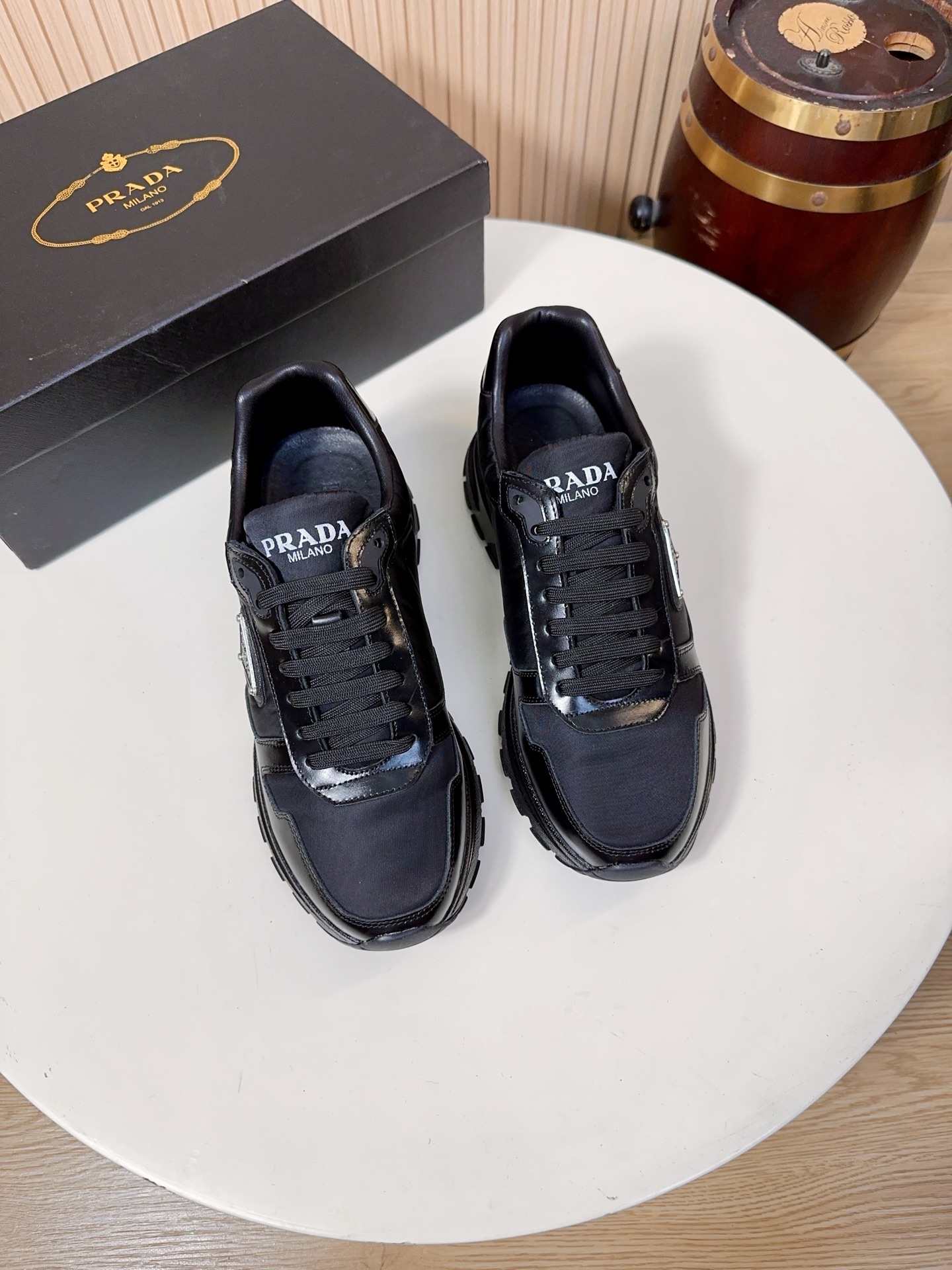 NO:834007,Prada is a top luxury brand founded in Milan, Italy in 1913. It subverts traditional avant-garde design and is recognized as a 'style definer' in the fashion industry. Prada's shoe series, especially sports shoes, has always been the benchmark for the high-end casual shoe market. (The upper material is Prada's iconic technical nylon + multi-material splicing) The main body of the shoe adopts Prada's iconic Re-high  (Microtech Mesh), this material is Prada's trump card material. It is lightweight, strong, breathable, waterproof and stain-resistant, and not easy to deform. It solves the problems of traditional leather shoes that are stuffy and difficult to care for. It is also one of Prada's core features that distinguishes it from other luxury brands. The toe is made of glossy leather material, which has a sense of luster. It is one of Prada's classic design elements, and the details are hidden in the low profile.  The lining and insole are standard features of Prada's high-end shoes. The lining is mostly made of lambskin, which is soft against the skin and does not rub the feet. The tongue and mouth of the shoe are also thickened; the insole has the Prada hot-stamped logo, and some styles use memory foam + genuine leather foot pads. While cushioning and rebounding, it can fit the shape of the foot, and the feet will not be tired after walking for a long time.  The soles are made of Prada's custom-made non-slip rubber material, with the brand's iconic anti-skid pattern design, which has strong grip and is not easy to slip on rainy days. It has been lightweight, with a single shoe weighing only about 300g, which greatly reduces the burden on the feet; the midsole has a cushioning structure  , Some styles use Prada’s lightweight foam technology, which combines support and comfort, and is suitable for daily commuting and short-distance travel. 38-44, A9,, prada, prada, sneakers, sheepskin19860909Prada（普拉达）是1913年创立于意大利米兰的顶级奢侈品牌,以颠覆传统的先锋设计,是时尚界公认的“风格定义者”.Prada的鞋履系列,尤其是运动鞋,一直是高端休闲鞋市场的标杆.（鞋面材质Prada标志性科技尼龙+多材质拼接）鞋身主体采用Prada标志性的Re-高密科技网布）,这种材质是Prada的王牌材质,兼具轻量化、强韧性与透气性,防水抗污、不易变形,解决了传统皮面鞋闷脚、难打理的问题,也是Prada区别于其他奢侈品牌的核心特征之一.鞋头搭配了亮面皮革材质,自带光泽感,是Prada经典的设计元素之一,低调中暗藏细节亮点. 内里与鞋垫Prada高端线鞋款的标配,内里多为羔羊皮,贴肤穿着柔软不磨脚,鞋舌、鞋口处也做了加厚处理；鞋垫带有Prada烫印标识,部分款式采用记忆棉+真皮垫脚,缓震回弹的同时,能贴合脚型,长时间走路也不累脚. 鞋底采用Prada定制的防滑橡胶材质,带有品牌标志性的防滑纹路设计,抓地力强,雨天也不易打滑；做了轻量化处理,单只鞋重量仅约300g,大幅减轻脚部负担；中底带有缓震结构,部分款式采用了Prada的轻量发泡科技,兼顾了支撑性与舒适感,适合日常通勤与短途出行.38-44,A9,,prada,prada,sneakers,sheepskin,Men's shoes