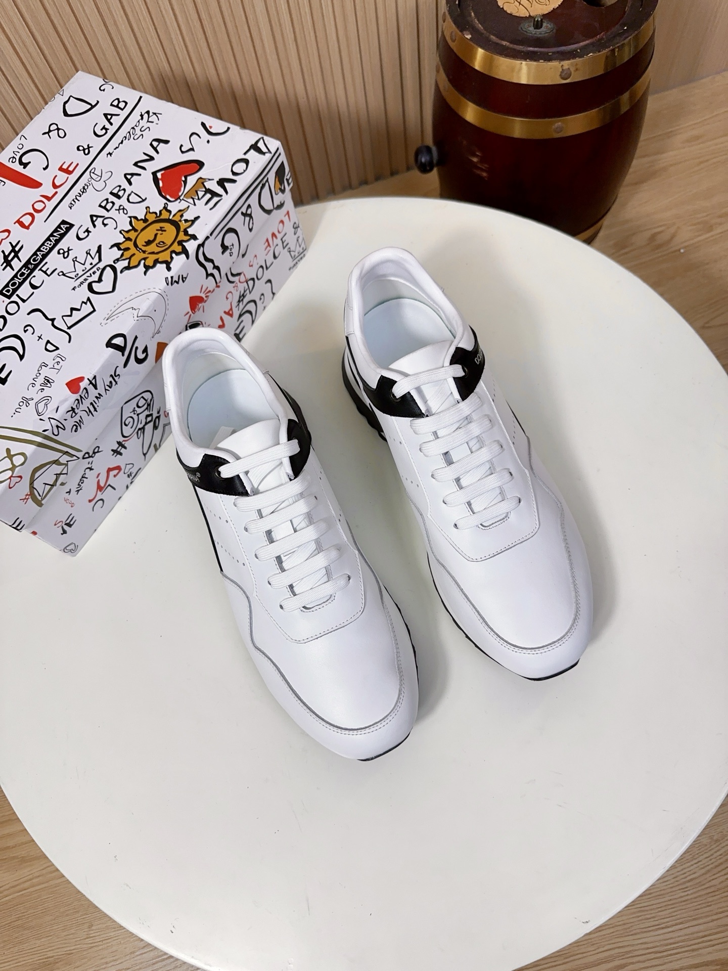 NO:834038,Dolce & Gabbana (referred to as D&G) is a top luxury brand born in Milan, Italy in 1985. It is as famous as Gucci and Prada. The brand focuses on light luxury texture and recognition, and is one of the benchmarks for high-end men's casual shoes.  The upper is made of imported first-layer cowhide + breathable mesh/splicing material. This kind of leather has a delicate and soft touch, a soft matte luster, strong toughness and is not easy to deform and crack. It can keep the shoe shape stiff even after long-term wear. It is a common material for high-end shoes of luxury brands. The shoes are breathable with a perforated/mesh design and leather splicing, which greatly improves the breathability of the upper, solves the problem of stuffy feet in pure leather white shoes, and can keep you dry and comfortable in spring and summer.  The black/gray leather splicing part on the side of the shoe is made of the same grade of cowhide material. The collision of leather with different textures makes the shoe body more layered and improves the wear resistance of the shoe side.  The lining and insole are standard features of high-end shoes. The lining is mostly made of lambskin, which is soft against the skin and does not rub the feet. The tongue and mouth of the shoe are also thickened; the insole has a brand hot-stamped logo, and some styles use memory foam + genuine leather foot pads. While cushioning and rebounding, it can fit the shape of the foot, and the feet will not be tired after walking for a long time.  The soles are made of brand-customized anti-slip rubber material with anti-slip texture design, which has strong grip and is not easy to slip in rainy days. It has been lightweighted, with a single shoe weighing only about 300g, which greatly reduces the burden on the feet. The midsole has a cushioning structure, which can disperse the pressure on the soles of the feet and take into account daily commuting.  Comfortable for short-distance travel.38-44,A9,,Dolce&Gabbana,Dolce&Gabbana,gucci,prada,Dolce&Gabbana,cowhide,sheepskin19860909Dolce & Gabbana（简称D&G,杜嘉班纳）是1985年诞生于意大利米兰的顶级奢侈品牌,与Gucci、Prada齐名.品牌主打轻奢质感与辨识度,是高端男士休闲鞋的标杆之一. 鞋面釆用进口头层牛皮+透气网眼/拼接材质这种皮革触感细腻柔软、自带柔和的哑光光泽,韧性强且不易变形开裂,长期穿着也能保持鞋型挺括,是奢侈品牌高端鞋履的常用材质.鞋子透气带有打孔/网眼设计,搭配皮革拼接,大幅提升了鞋面的透气性,解决了纯皮面小白鞋闷脚的问题,春夏穿着也能保持干爽舒适. 鞋侧的黑/灰色皮革拼接部分,采用同等级的牛皮材质,不同质感的皮革碰撞,让鞋身更具层次感,也提升了鞋侧的耐磨性. 内里与鞋垫高端线鞋款的标配,内里多为羔羊皮,贴肤穿着柔软不磨脚,鞋舌、鞋口处也做了加厚处理；鞋垫带有品牌烫印标识,部分款式采用记忆棉+真皮垫脚,缓震回弹的同时,能贴合脚型,长时间走路也不累脚. 鞋底采用品牌定制的防滑橡胶材质,带有防滑纹路设计,抓地力强,雨天也不易打滑；做了轻量化处理,单只鞋重量仅约300g,大幅减轻脚部负担；中底带有缓震结构,能分散足底压力,兼顾日常通勤与短途出行的舒适感.38-44,A9,,Dolce&Gabbana,Dolce&Gabbana,gucci,prada,Dolce&Gabbana,cowhide,sheepskin,Men's shoes