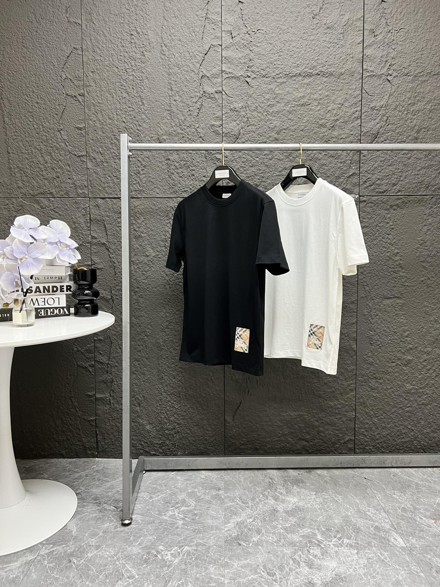 BURBERRY博柏利 FW25下摆战马标签圆领短袖T恤 黑色 白色 S到XL~ 专柜原版购入 三本针走线 YB开发代购订单 所有细节与原版一致 去年买过咱家Bb短袖和POLO衫款式的客户 都知道含金量! 原版定织定染190克重20支精梳棉平纹面料,高密度的面料肌理感清晰可见,柔软舒适,透气性非常好,吸汗不闷热,质感拉满 好面料 上身才更有型! 采用圆领款式,螺纹针织领口,下摆装饰有Bbr家的格纹标签贴花 采用50D精纱织密而成 下摆战马标纹路感 立体感 质感统统拉满!采用特种锁边机 半三角勾线缝入衣服上 反面无线头 全锁边工艺 大厂做工~ 整件衣服从肩膀到下摆 全部采用三本针走线 区分市面2针通货走线 脖后领口全部与原版一致的打枣套结工艺 还原原版的精致做工! 领标水洗标吊牌 都是25年专柜最新款的定制辅料 洗标带货号 还有单独的水洗尺码标 越小的细节 越不能忽略!实拍所见即所得! 身高160,体重110,穿S 身高168,体重135,穿M, 身高175,体重160,穿L 身高180,体重180,穿XL