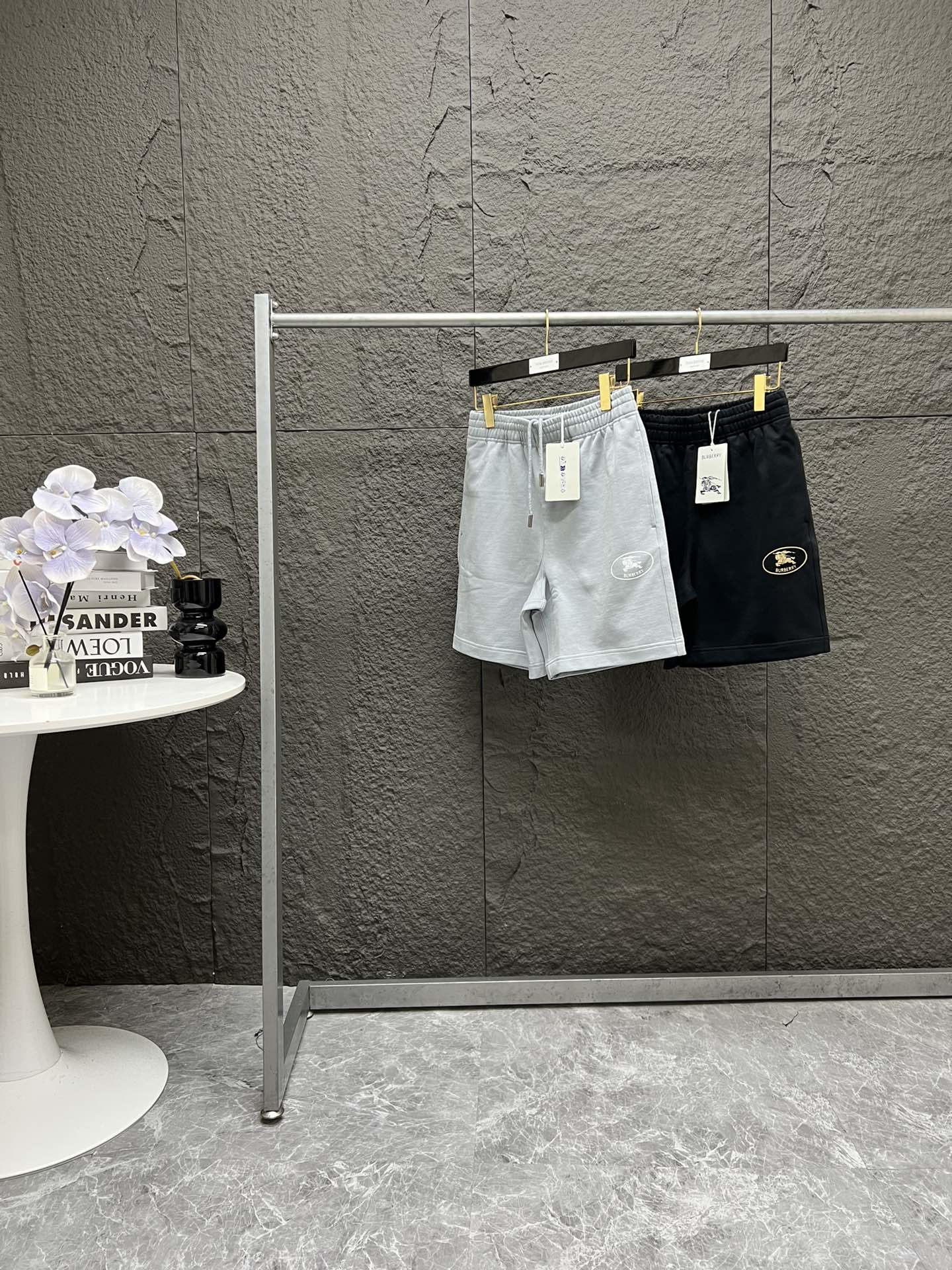 Burberry博柏利 SS25 EKD骑士标志棉质休闲短裤 男女同款 S到XL 黑色 烟灰色~ 全新bbr短裤面料为100%全棉32支纱400克卫衣毛圈面料 质感拉满 上身很舒适~ 裤脚印花采用活性胶浆 手工网版印花 上百次洗衣机搅洗实验 印花不脱落不开裂不掉色! 腰绳五金绳头 全部开模定制 都带有Bb家的字母logo 腰绳也是定染 跟短裤面料 0色差搭配 拒绝一眼色差的通货版本! 水洗标货号 均与柜柜一致 随便对比某物在售版本 吊牌 领标都是25年最新款柜柜一致~ 码数试穿: 模特A:身高170,体重120,穿S码 模特B:身高177,体重150,穿M码 模特C:身高180,体重170,穿L码 模特D:身高185,体重190,穿XL码