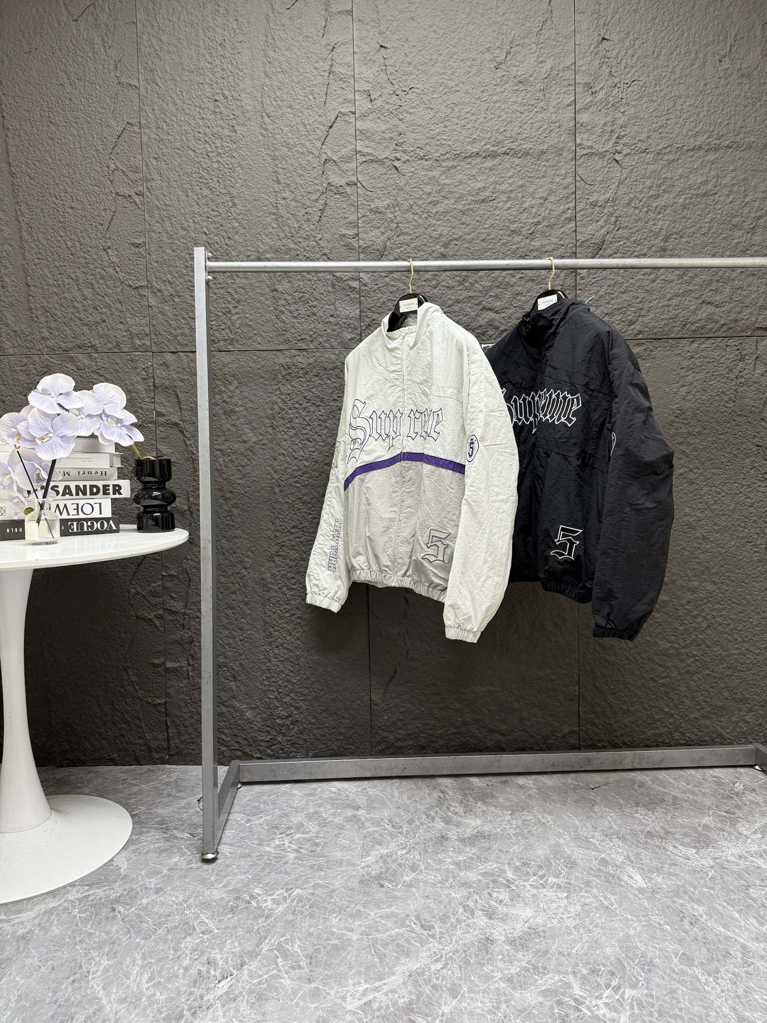 P260 顶级潮流套装 Supreme SS25 WEEK12 Old English Track Jacket 徽标图案贴花拉链开合立领美式潮流夹克外套 裤子 套装 男女同款 

-    颜色：灰白 黑色
-    尺码：S M L XL （175 145穿M）
            S      M     L	  XL
胸围：	150	  154  158	162
衣长：	 70	   72     74	  76
袖长：	 62	   63     64	  65
肩宽：	 61	   62	63   64
强烈推荐搭配套装，原版购入开发，重工品质，大身超多刺绣logo标识，缜密细腻都是进口机器出货！！内里有网眼布，透气不贴身同时成本非常高！！整体大身拼接分割，衣身重工多处刺绣，同色系Ykk拉链丝滑无比！！全套配置辅料堆满，必须顶级品质！