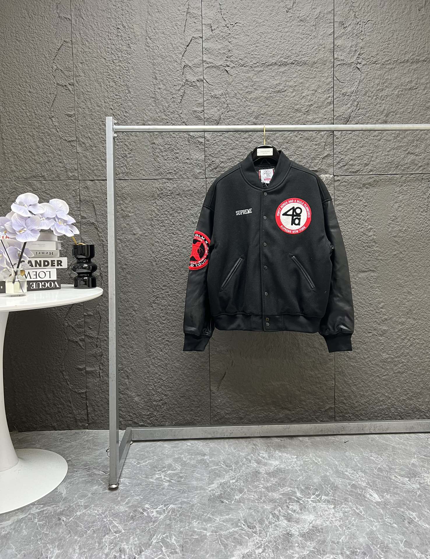 P280 原版复刻单品  Supreme x 40 Acres 联名款 SS25 WEEK9 Malcolm X Varsity Jacket 圆形毛绒徽标logo休闲美式潮流夹克 男女同款  宽松版型
颜色：黑色
尺码：S   M   L   XL
      胸围   衣长    肩宽    袖长
S:   142       70       60       62
M:  146       72       62       63
L:    150      74      63.5     64
xL:  154      76      64.5     65

今年的全系列热门单品，今天带来秋冬季节夹克外套！！大身毛呢面料，袖子皮料为进口皮料整体有皮质感同时哑光效果！！下摆领口袖口都有加密螺纹！！胸口品牌Sup缜密小刺绣，左侧又点缀40联名毛巾绣！！后背超大X刺绣logo！！主标领标都是定制带联名logo！！内里菱形格填充棉，秋冬季节足够！！十星⭐狠货，强烈推荐✔️✔️✔️