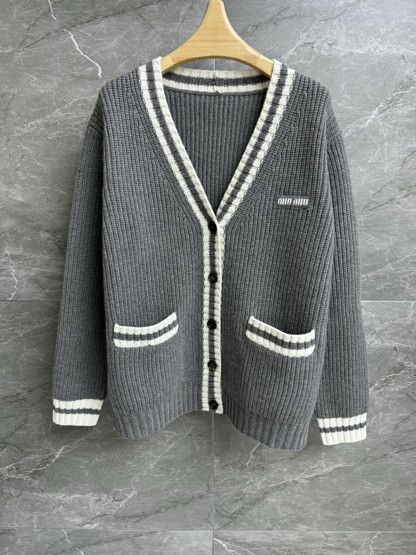 NO:294213,New early spring style is available. Miu gray cashmere cardigan. 2025 early spring series. Temperament V-neck neckline. Embroidered logo logo decoration. Gray and white contrasting ribbed trim. Age-reducing college style. Wool cashmere blended fabric. Thick, soft and comfortable. Loose style. Slim and versatile upper body. Full trademark. Size SML,,miumiu,alexander wang.19860909早春新款上新啦 Miu灰色羊绒开衫 2025早春系列 气质V领领口 刺绣logo徽标装饰 灰白撞色罗纹饰边 减龄学院风 羊毛羊绒混纺面料 厚实软糯舒适 宽松版型 上身显瘦又百搭 商标齐全 尺码SML,,miumiu,alexander wang,Women's clothing