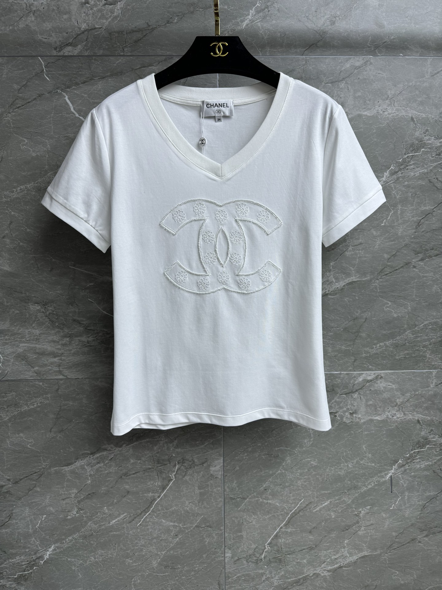 NO:295401,New early spring style is available. Xiangjia beaded logo T-shirt 2025 early spring series. Temperament V-neck neckline. Double C beaded logo pattern. Exquisite and fashionable. Imported pure cotton fabric. Comfortable and skin-friendly and breathable. Normal style. Slim and versatile. Full trademark. Size SML, chanel,tees, t-shirt,alexander wang.19860909早春新款上新啦 香家钉珠logoT恤 2025早春系列 气质V领领口 双C钉珠logo图案 精致时髦 进口纯棉面料 舒适亲肤透气 正常版型 上身显瘦又百搭 商标齐全 尺码SML,,chanel,tees，t-shirt,alexander wang,Women's clothing