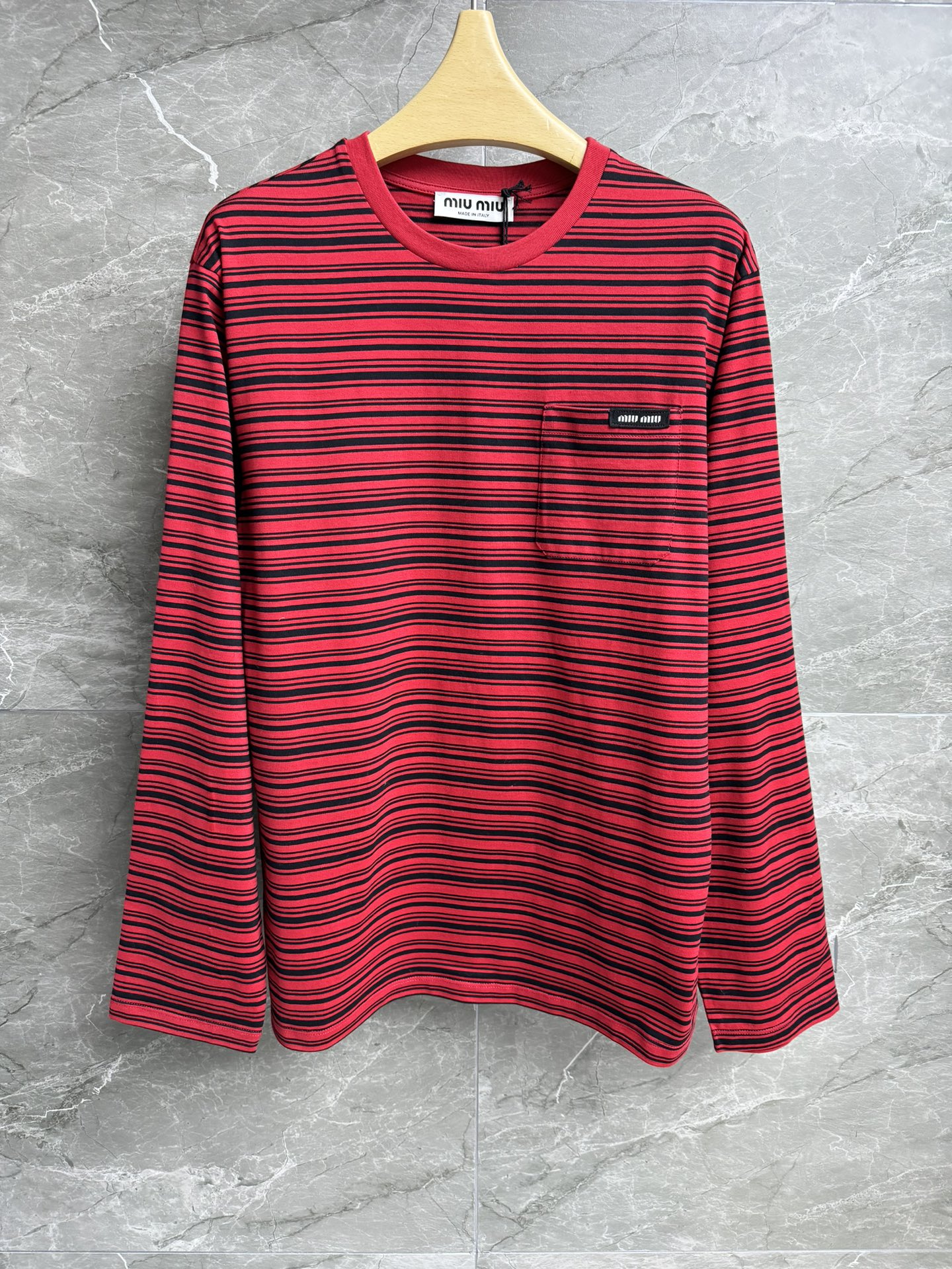 NO:306876,New early spring model is available. Miu red and black striped long-sleeved T-shirt 2025 early spring series. Round neckline design. Pocket logo logo decoration embellishment. Red and black striped contrasting color. Imported pure cotton fabric. Light, comfortable and breathable. Loose style. Slim and versatile. Full trademark. Size SM,,miumiu,tees, t-shirt,alexander wang.19860909早春新款上新啦 Miu红黑条纹长袖T恤 2025早春系列 圆领领口设计 口袋logo徽标装饰点缀 红黑条纹撞色 进口纯棉面料 轻薄舒适透气 宽松版型 上身显瘦又百搭 商标齐全 尺码SM,,miumiu,tees，t-shirt,alexander wang,Women's clothing
