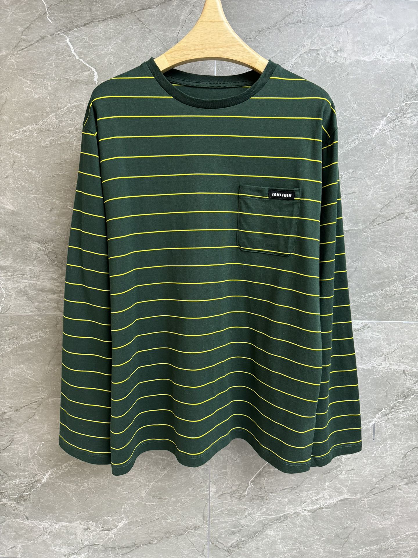 NO:309029,New early spring model is available. Miu green striped long-sleeved T-shirt 2025 early spring series. Round neckline design. Pocket logo logo embellishment. Green striped contrasting color. Imported pure cotton fabric. Light, comfortable and breathable. Loose style. Slim and versatile. Full trademark. Size SM,,miumiu,tees, t-shirt,alexander wang.19860909早春新款上新啦 Miu绿色条纹长袖T恤 2025早春系列 圆领领口设计 口袋logo徽标装饰点缀 绿色条纹撞色 进口纯棉面料 轻薄舒适透气 宽松版型 上身显瘦又百搭 商标齐全 尺码SM,,miumiu,tees，t-shirt,alexander wang,Women's clothing