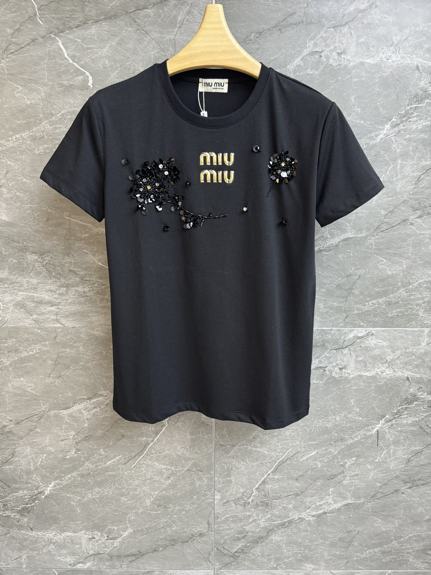 NO:321469,New early spring style is available. Miu three-dimensional letter flower T-shirt 2025 early spring series. Round neckline design. Three-dimensional letter printing   sequin bead flower embroidery. Exquisite and fashionable age-reducing. Imported pure cotton fabric. Comfortable and skin-friendly and breathable. Normal style. Slim and temperament on the upper body. Full trademark. Size SML,,miumiu,tees, t-shirt,alexander wang.19860909早春新款上新啦 Miu立体字母花朵T恤 2025早春系列 圆领领口设计 立体字母印花 亮片钉珠花朵刺绣 精致时髦减龄 进口纯棉面料 舒适亲肤透气 正常版型 上身显瘦又气质 商标齐全 尺码SML,,miumiu,tees，t-shirt,alexander wang,Women's clothing