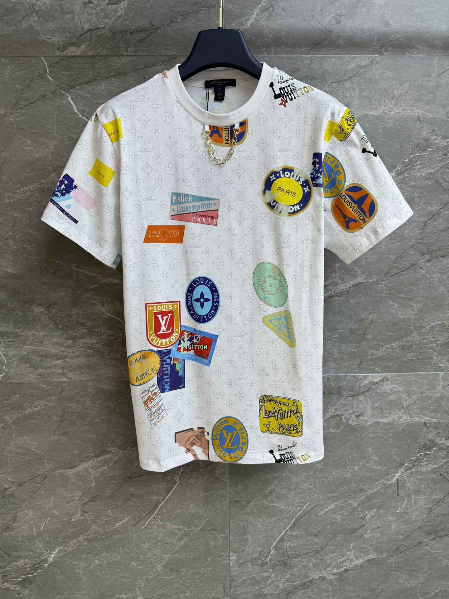 NO:328094,New spring and summer models are shipped. L family color badge printed T-shirt. 2025 spring and summer series. Round neckline contrasting collar. Decorated with chain decoration. Classic dark pattern and colorful flying seal pattern. Fashionable and high-end imported pure cotton material. Comfortable and skin-friendly. Loose style. Slim and temperament on the upper body. Full trademark. Size SML,,louis vuitton,tees, t-shirt,alexander wang.19860909春夏新款出货啦 L家彩色徽章印花T恤 2025春夏系列 圆领撞色领口 饰以链条装饰点缀 经典暗纹老花搭配彩色飞行印章图案 时髦高级 进口纯棉材质 舒适亲肤 宽松版型 上身显瘦又气质 商标齐全 尺码SML,,louis vuitton,tees，t-shirt,alexander wang,Women's clothing