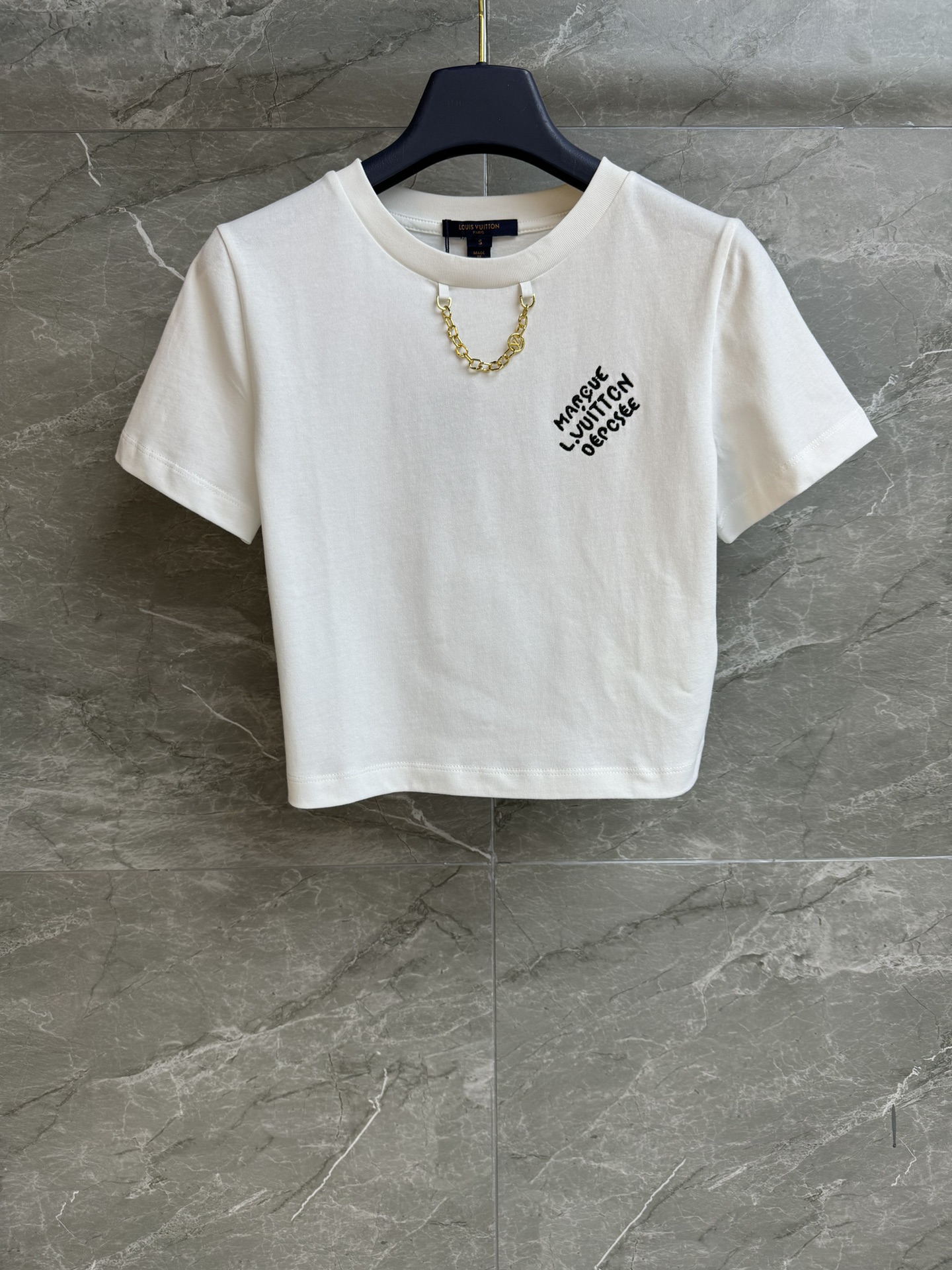 NO:332453,New spring and summer models are shipped!  L's letter embroidery T-shirt 2025 spring and summer series round neck neckline design metal chain decorative neckline letter logo embroidery pattern embellishment simple and high-end customized cotton fabric comfortable and skin-friendly short style upper body slim and versatile trademark full size SML,,louis vuitton,tees, t-shirt,alexander wang19860909春夏新款出货啦！ L家字母刺绣T恤 2025春夏系列 圆领领口设计 金属链条装饰领口 字母logo刺绣图案点缀 简约又高级 定制纯棉面料 舒适亲肤 短款版型 上身显瘦又百搭 商标齐全 尺码SML,,louis vuitton,tees，t-shirt,alexander wang,Women's clothing