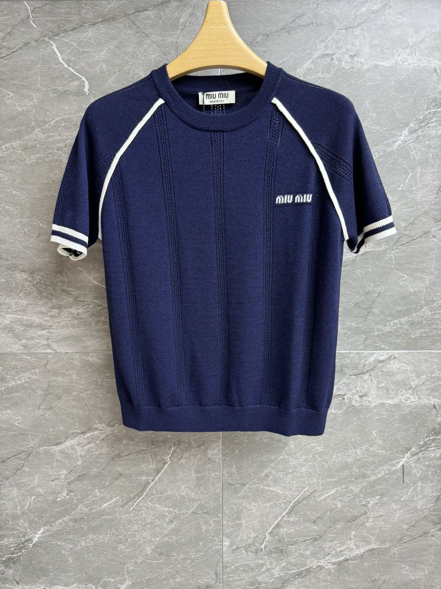 NO:418788,New summer models are available. Miu navy blue knitted short sleeves. 2025 summer series. Round neck ribbed neckline. Blue and white contrasting design. Letter inlay logo embellishment. Casual and age-reducing high-end customized knitted fabric. Lightweight, comfortable and skin-friendly. Normal style. Slim and versatile. Full trademark. Size SML,,miumiu, T-shirt,alexander wang.19860909夏季新款上新啦 Miu藏蓝色针织短袖 2025夏季系列 圆领罗纹领口 蓝白撞色设计 字母嵌花logo点缀 休闲减龄高级 定制针织面料 轻薄舒适亲肤 正常版型 上身显瘦又百搭 商标齐全 尺码SML,,miumiu,T-shirt,alexander wang,Women's clothing