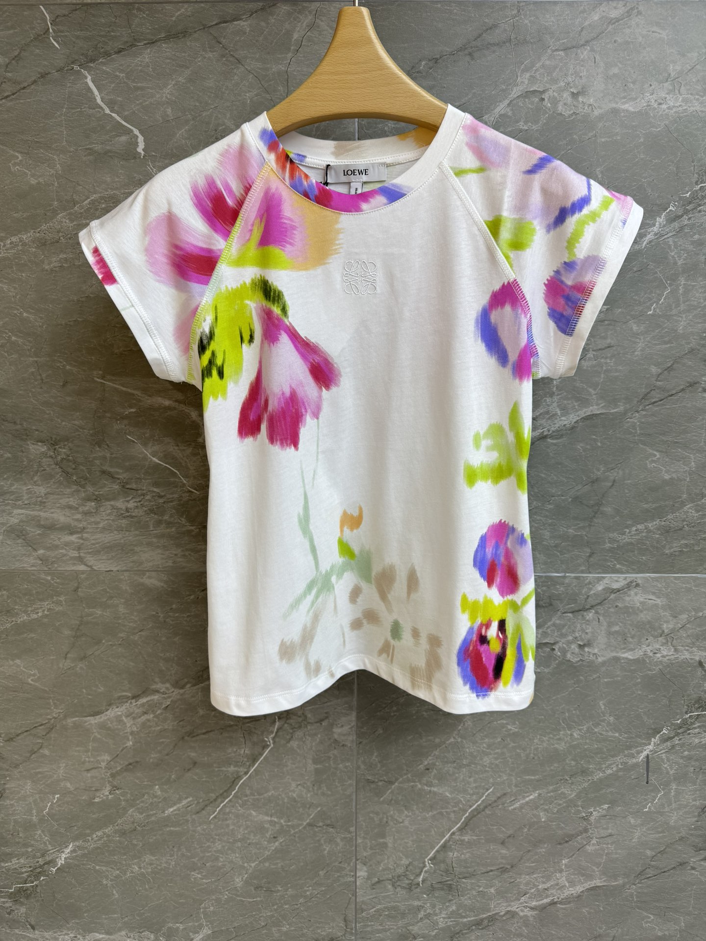 NO:429442,New summer style is available. Luo Yiwei floral print T-shirt 2025 summer series. Round neckline design. Embroidery embroidery on the chest. Colorful floral print pattern. Fashionable and age-reducing. Imported pure cotton fabric. Comfortable and skin-friendly. Slim fit. The upper body looks slim and versatile. Full trademark. Size SML,,loewe,tees, t-shirt,alexander wang.19860909夏季新款上新啦 罗意威花卉印花T恤 2025夏季系列 圆领领口设计 胸前logo刺绣点缀 彩色花卉印花图案 时髦减龄 进口纯棉面料 舒适亲肤 修身版型 上身显瘦又百搭 商标齐全 尺码SML,,loewe,tees，t-shirt,alexander wang,Women's clothing