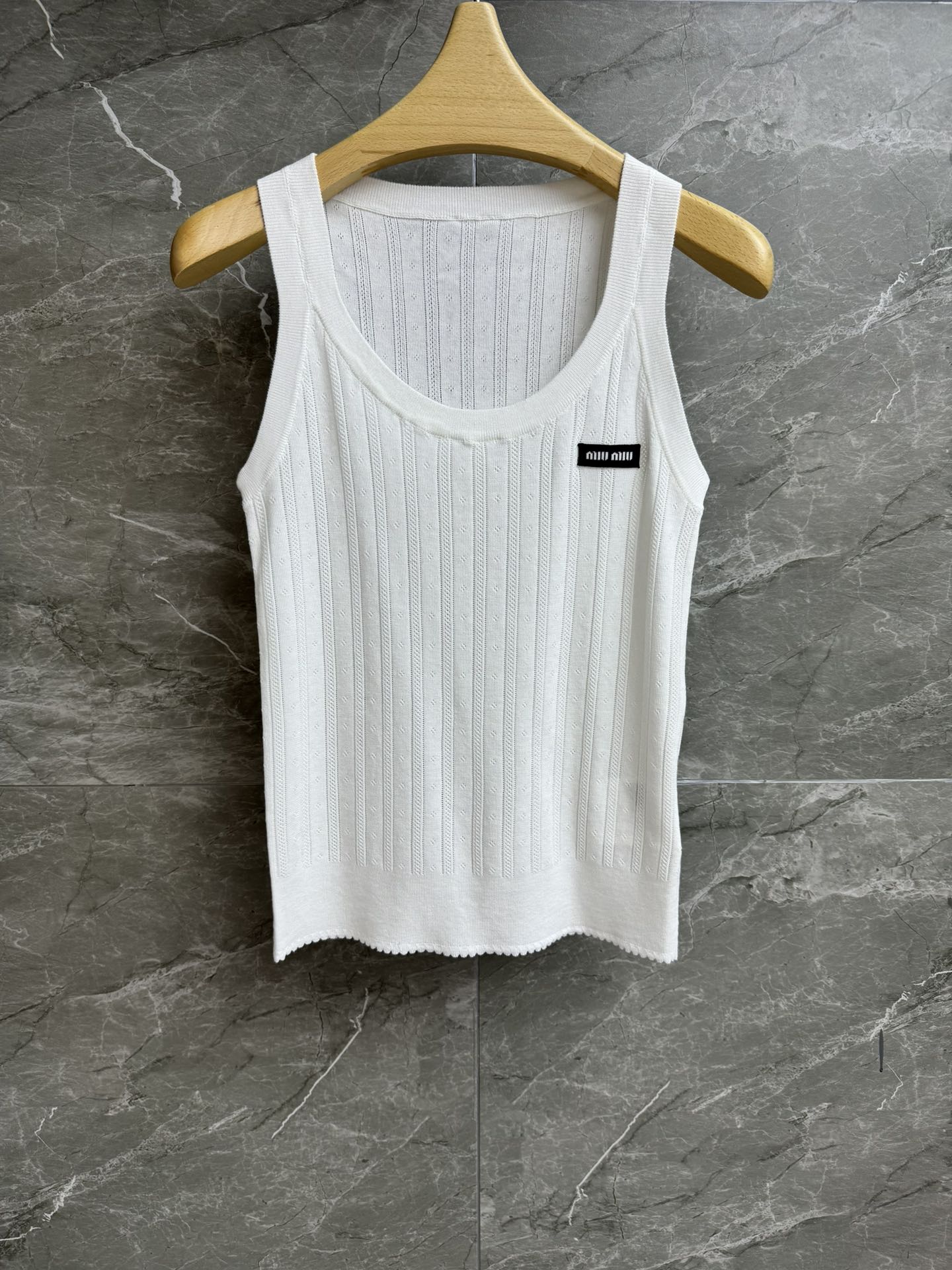 NO:435869,High-end version is shipped. Miu hollow knitted vest. 2025 spring and summer series. Versatile U-neck neckline. Alphabet logo embellishment. Lace hollow jacquard. Sweet and age-reducing. Cotton knitted fabric. Light and comfortable. Elastic slim fit. The upper body looks slim and versatile. Full trademark. Size SML,,miumiu,alexander wang.19860909高版本出货啦 Miu镂空针织背心 2025春夏系列 百搭U领领口 字母logo徽标点缀 蕾丝镂空提花 甜美减龄 棉质针织面料 轻薄舒适 弹力修身版型 上身显瘦又百搭 商标齐全 尺码SML,,miumiu,alexander wang,Women's clothing