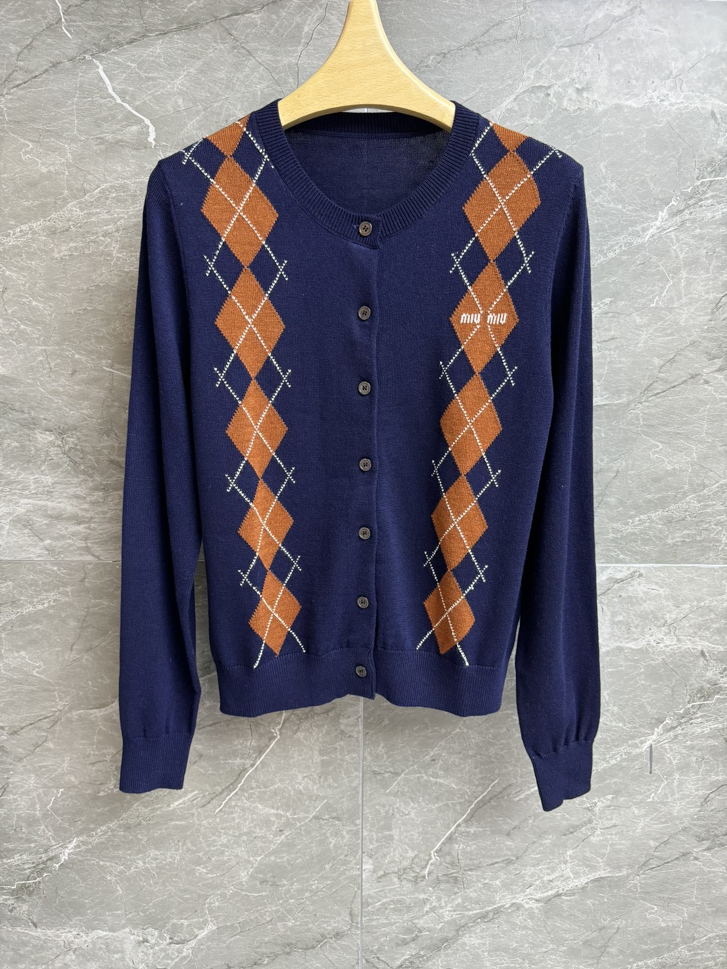 NO:453691,New models for early autumn are available. Miu diamond knitted cardigan 2025 early autumn series. Round neck single-breasted design. Diamond letter inlay pattern. Retro and fashionable color matching. Wool knitted fabric. Soft and glutinous skin-friendly. Slim fit. The upper body looks slim and temperament. Layable and wearable. Full trademark. Size SMl,,miumiu,alexander wang.19860909早秋新款上新啦 Miu菱格针织开衫 2025早秋系列 圆领单排扣设计 菱格字母嵌花图案 配色复古时髦 羊毛针织面料 软糯亲肤 修身版型 上身显瘦又气质 可叠穿搭配 商标齐全 尺码SMl,,miumiu,alexander wang,Women's clothing