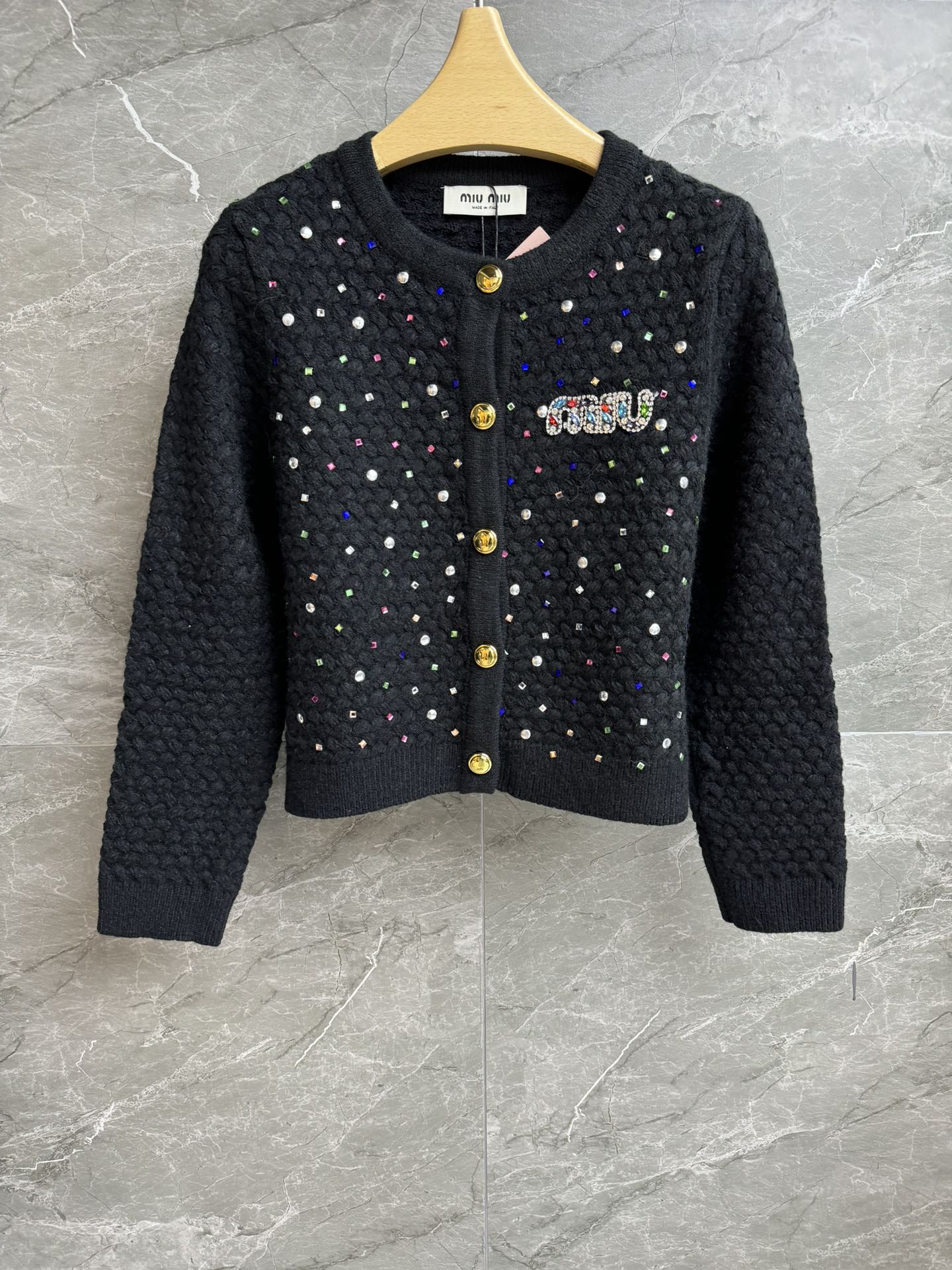 NO:471913,New models for early autumn are available. Miu hot diamond knitted cardigan 2025 early autumn series. Round neckline design. Heavy industry nail bead hot diamond decoration. Exquisite and fashionable. Wool blended knitted fabric. Thick and comfortable. Normal style. Slim and temperament on the upper body. Full trademark. Size SML,,miumiu,alexander wang.19860909早秋新款上新啦 Miu烫钻针织开衫 2025早秋系列 圆领领口设计 重工钉珠烫钻装饰 精致时髦高级 羊毛混纺针织面料 厚实舒适 正常版型 上身显瘦又气质 商标齐全 尺码SML,,miumiu,alexander wang,Women's clothing