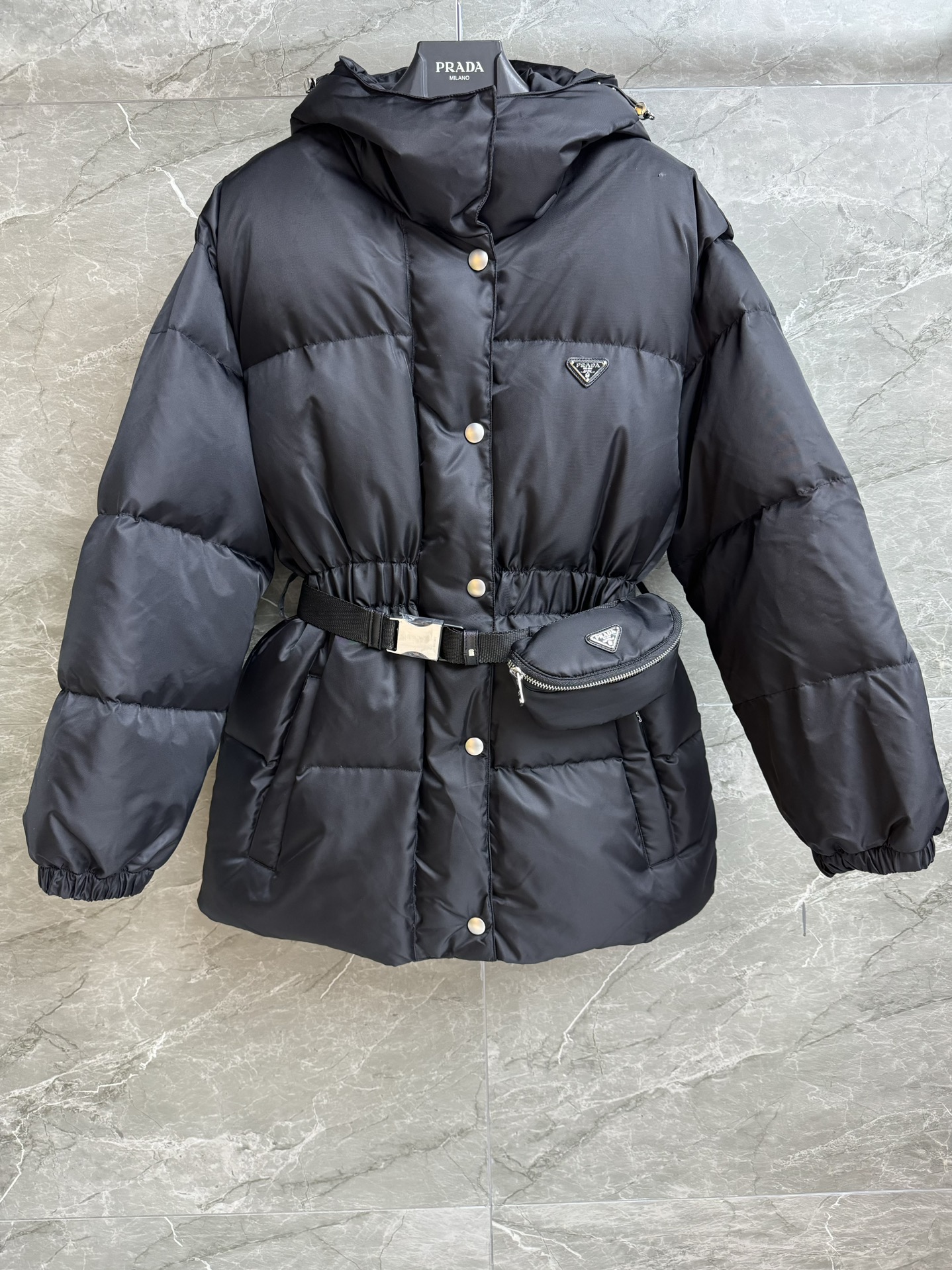 NO:473028,New autumn and winter models with dust bags are available. P home waist bag hooded down jacket. 2025 autumn and winter series. Hooded design windproof and warm. Equipped with waist packaging. Fashionable and high-end custom recycled nylon fabric. 90 white goose down filling. Cold-proof and warm. Medium-length waist-hugging style. The upper body looks slim and fashionable. Customized hardware logos are complete. Perfect details. Size SMl,, down jacket, hats, alexander wang.19860909配防尘袋秋冬新款上新啦 P家腰包连帽羽绒服 2025秋冬系列 连帽设计防风保暖 配有腰包装饰 时髦高级 定制再生尼龙面料 90白鹅绒填充 防寒保暖 中长款收腰版型 上身显瘦又时髦 定制五金logo齐全 细节完美 尺码SMl,,down jacket,hats,alexander wang,Women's clothing