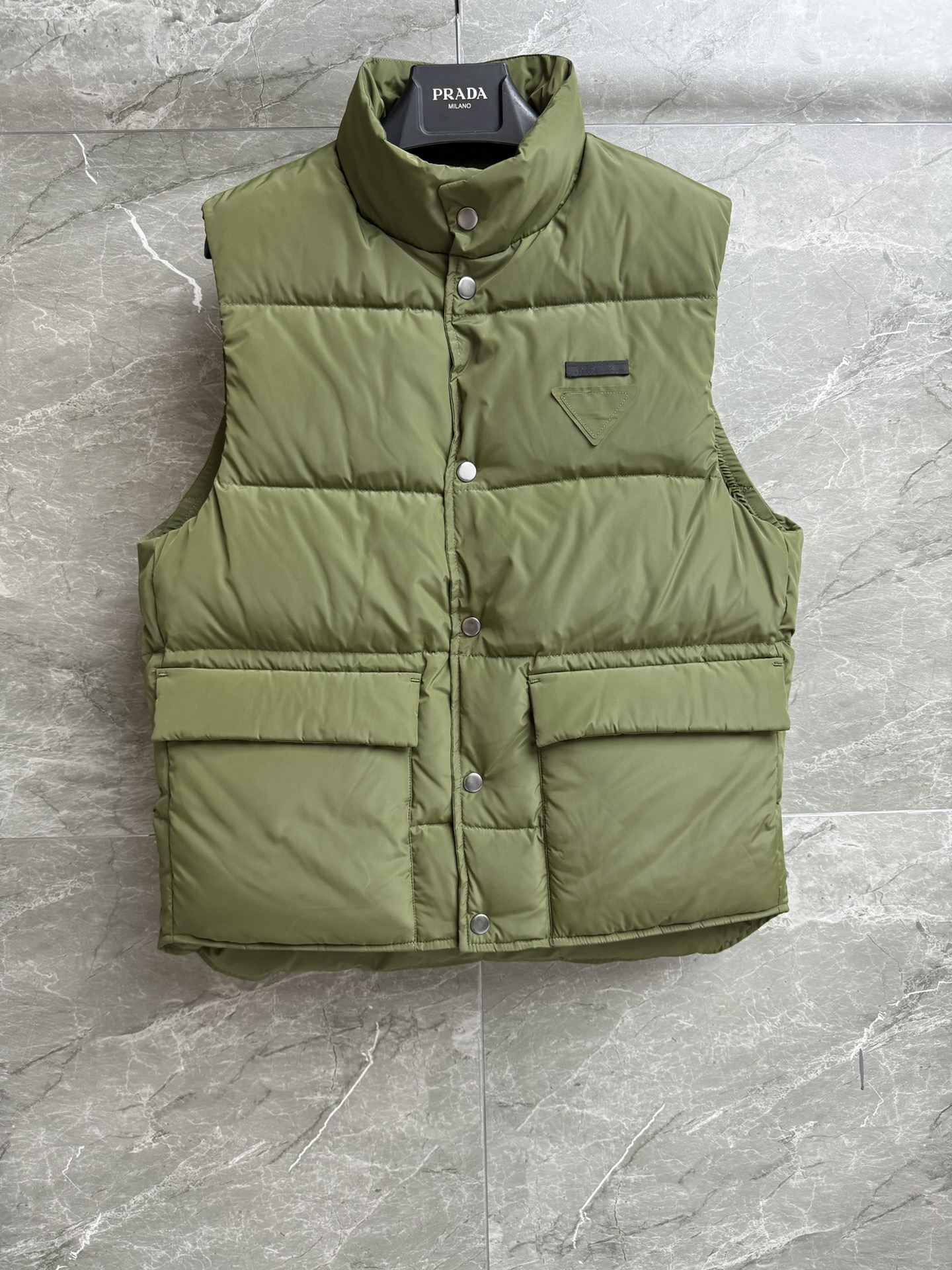 NO:490475,New autumn and winter models with dust bags are available. P home stand-up collar down vest. 2025 autumn and winter series stand-up collar design. Triangular logo embellishment on chest. Military green retro fashionable. Recycled nylon fabric. 90 white goose down filling. Fully filling. Warm and comfortable. Straight-tube loose style. Slim and versatile. Full trademark. Size SML, down jacket, alexander wang.19860909配防尘袋秋冬新款上新啦 P家立领羽绒马甲 2025秋冬系列 立领领口设计 胸前三角logo徽标点缀 军绿色复古时髦 采用再生尼龙面料 90白鹅绒填充 充绒量足 保暖舒适 直筒宽松版型 上身显瘦又百搭 商标齐全 尺码SML,,down jacket,alexander wang,Women's clothing