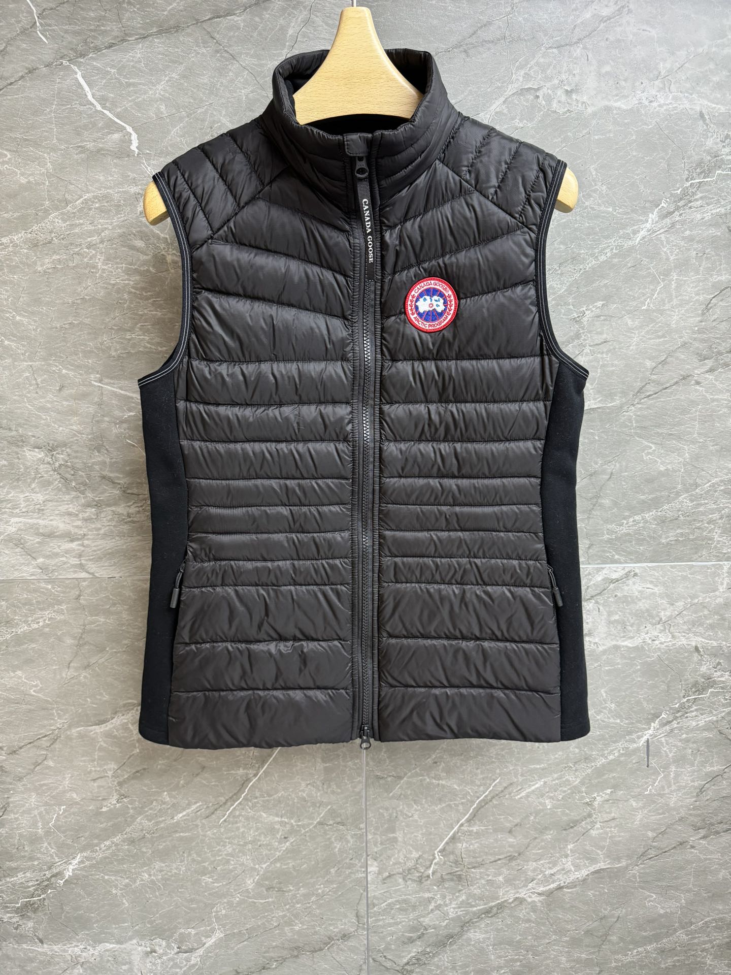 NO:549807,The new autumn and winter style with dust bag is available. Canadian goose down vest. 2025 autumn and winter series. Stand-up collar zipper design. Elastic cloth on both sides of the armpits increases elasticity and highlights the figure. Classic logo badge embellishments on the chest. Casual minimalist and high-end 90 duck down filling. Sporty and light and comfortable. Slim fit style. The upper body looks slim and versatile. Full trademark. Size SML, down jacket, alexander wang.19860909配防尘袋秋冬新款上新啦 加拿大鹅羽绒马甲 2025秋冬系列 立领拉链设计 腋下两侧拼接弹力布 增加弹力又凸显身材 胸前经典logo徽章点缀 休闲极简高级 90鸭绒填充 运动轻薄舒适 修身版型 上身显瘦又百搭 商标齐全 尺码SML,,down jacket,alexander wang,Women's clothing