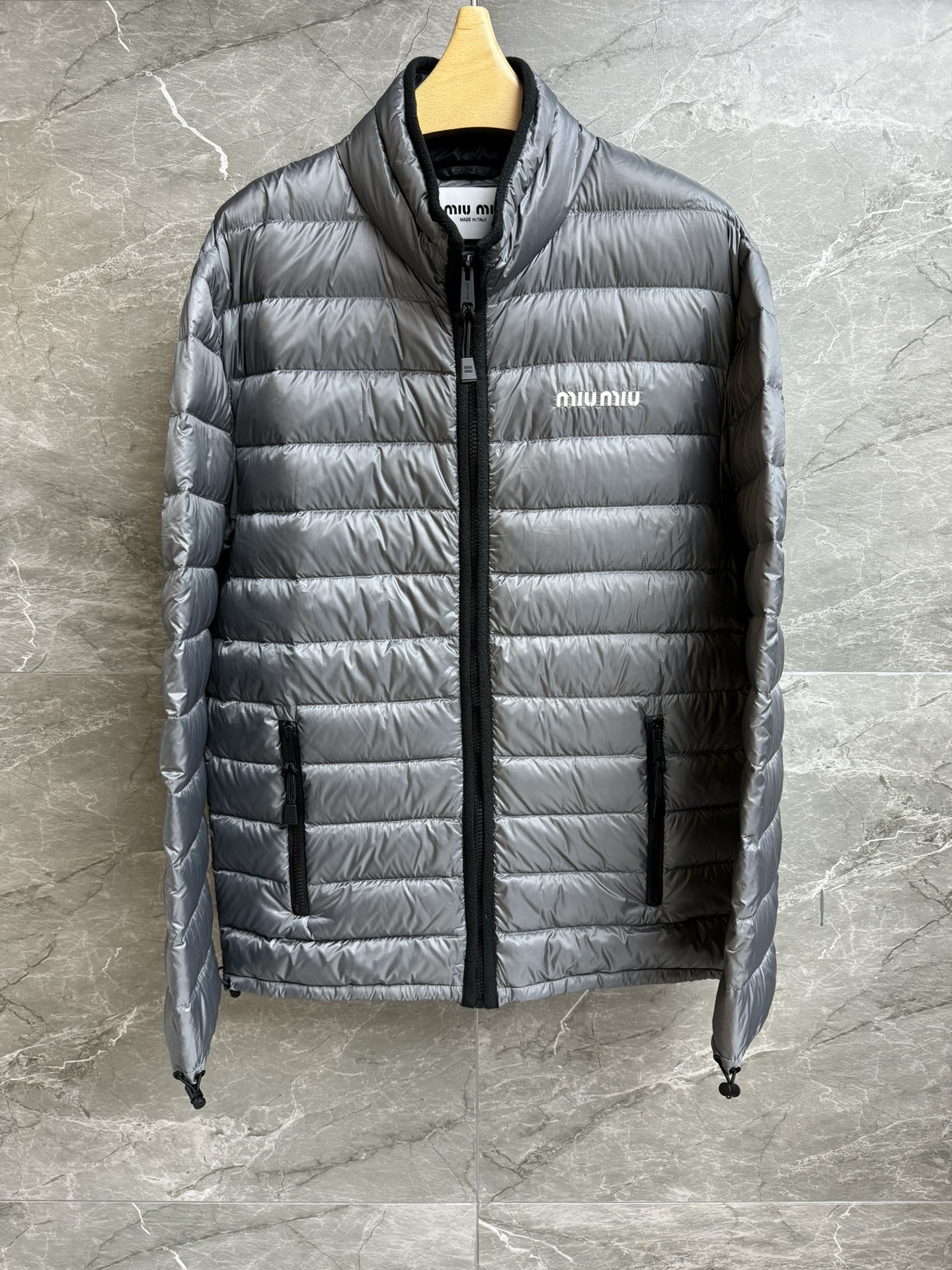 NO:587780,Comes with dust bag for autumn and winter. Miu gray down jacket 2025 autumn and winter series. Stand collar zipper design. Letter logo embroidery on chest. Silver gray color. Fashionable and advanced. Customized lightweight nylon fabric. 90 white goose down filling. Lightweight, warm and comfortable. Straight fit. The upper body is slim and versatile. Complete trademarks. Sizes SML, miumiu, down jacket, alexander wang19860909配防尘袋秋冬新款上新啦 Miu灰色羽绒服 2025秋冬系列 立领拉链设计 胸前字母logo刺绣点缀 银灰色配色 时髦高级 定制轻质尼龙面料 90白鹅绒填充 轻盈保暖舒适 直筒版型 上身显瘦又百搭 商标齐全 尺码SML,,miumiu,down jacket,alexander wang,Women's clothing