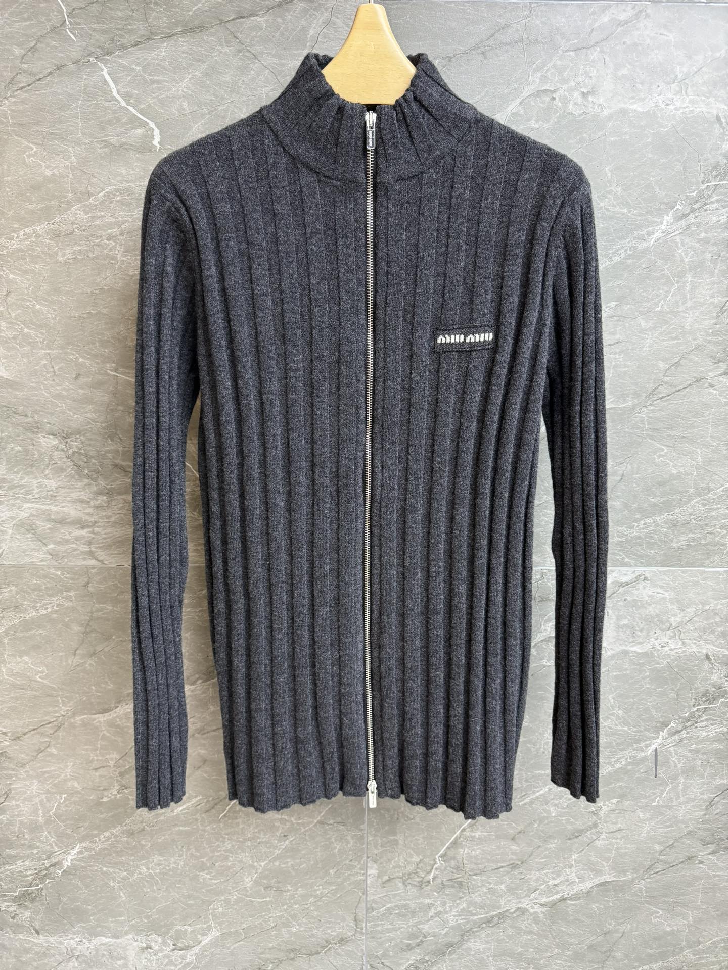 NO:611630,Autumn and winter new models have been shipped. Miu gray vertical striped cardigan 2025 autumn and winter series. Stand-up collar zipper design. Rib knitted vertical stripe texture. Dark gray color matching is simple and advanced. Wool knitted fabric. Soft and comfortable. Stretch slim fit. The upper body is slim and elegant. Complete trademarks. Sizes SML, miumiu, alexander wang19860909秋冬新款出货啦 Miu灰色竖条纹开衫 2025秋冬系列 立领拉链设计 罗纹针织竖条纹理 深灰配色简约高级 羊毛针织面料 软糯舒适 弹力修身版型 上身显瘦又气质 商标齐全 尺码SML,,miumiu,alexander wang,Women's clothing