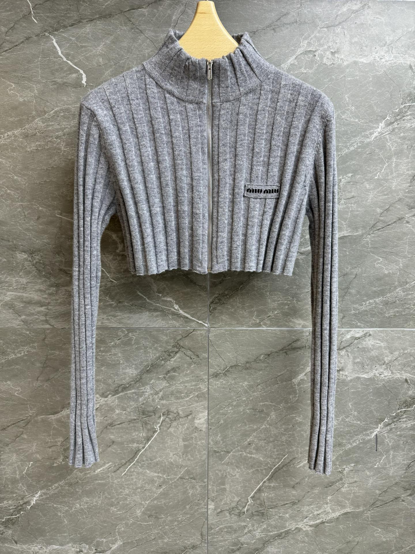 NO:611638,The new autumn and winter models are on sale. Miu gray short cardigan 2025 autumn and winter series. Stand-up collar zipper design. Letter logo embroidery embellishment on the chest. Vertical pit strip texture. Wool knitted fabric. Soft and comfortable. Ultra-short version. The upper body looks slim and fashionable. Complete trademarks. Sizes SML, miumiu, alexander wang19860909秋冬新款出货啦 Miu灰色短款开衫 2025秋冬系列 立领拉链设计 胸前字母徽标刺绣点缀 竖坑条纹理 羊毛针织面料 软糯舒适 超短款版型 上身显瘦又时髦 商标齐全 尺码SML,,miumiu,alexander wang,Women's clothing