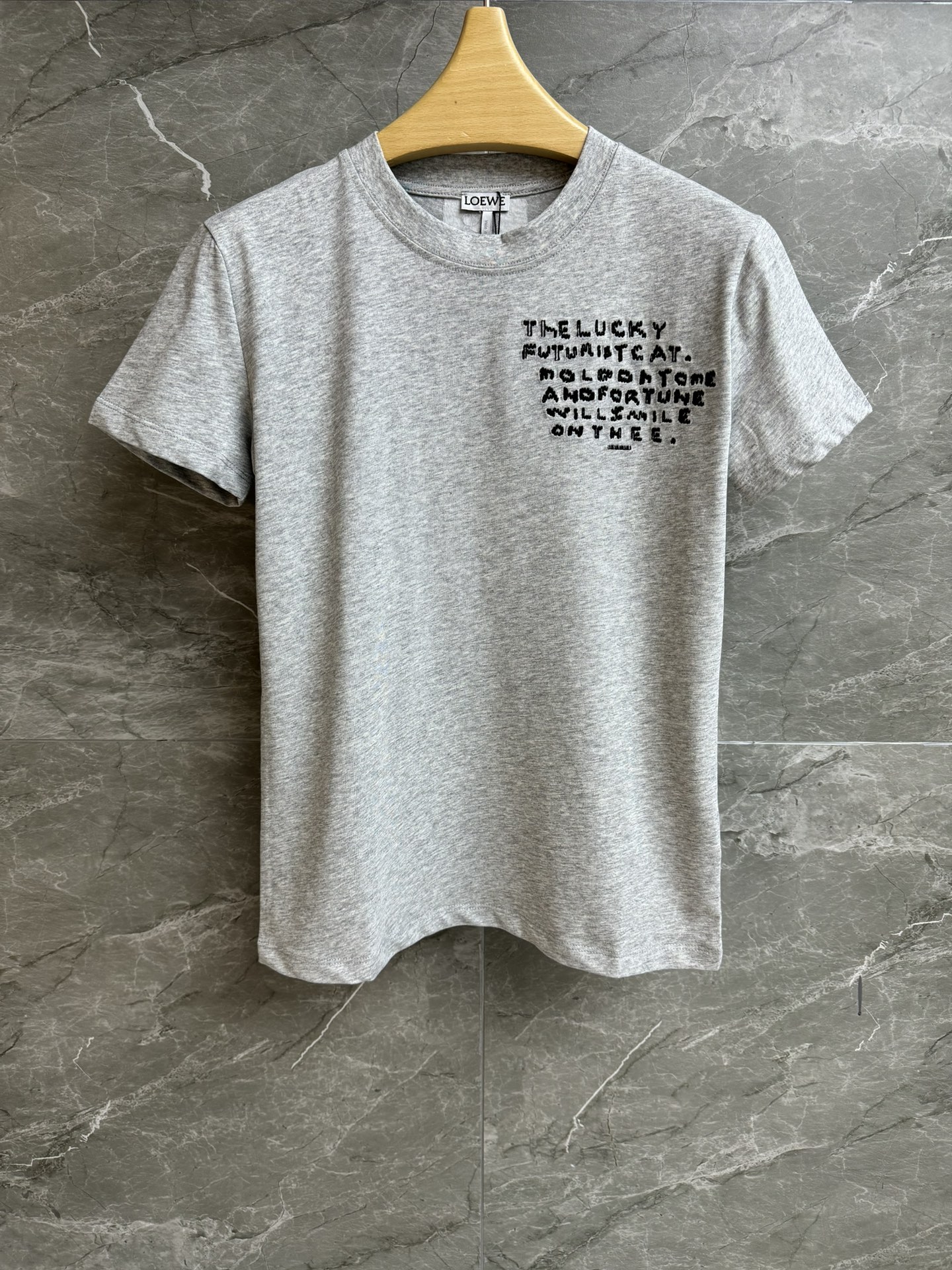 NO:621773,New styles for early spring are available. Loewe gray embroidered T-shirt 2026 early spring series. Round neck design. Letter embroidery on the chest. Cross-stitch cat embroidery pattern on the back. Personalized fashion. Customized pure cotton fabric. Comfortable and skin-friendly. Normal fit. The upper body is slim and versatile. Complete trademarks. Sizes SML, loewe, tees, t-shirt, alexander wang19860909早春新款上新啦 罗意威灰色刺绣T恤 2026早春系列 圆领领口设计 胸前绣有字母刺绣 后背十字绣猫咪刺绣图案 个性时尚 定制纯棉面料 舒适亲肤 正常版型 上身显瘦又百搭 商标齐全 尺码SML,,loewe,tees，t-shirt,alexander wang,Women's clothing