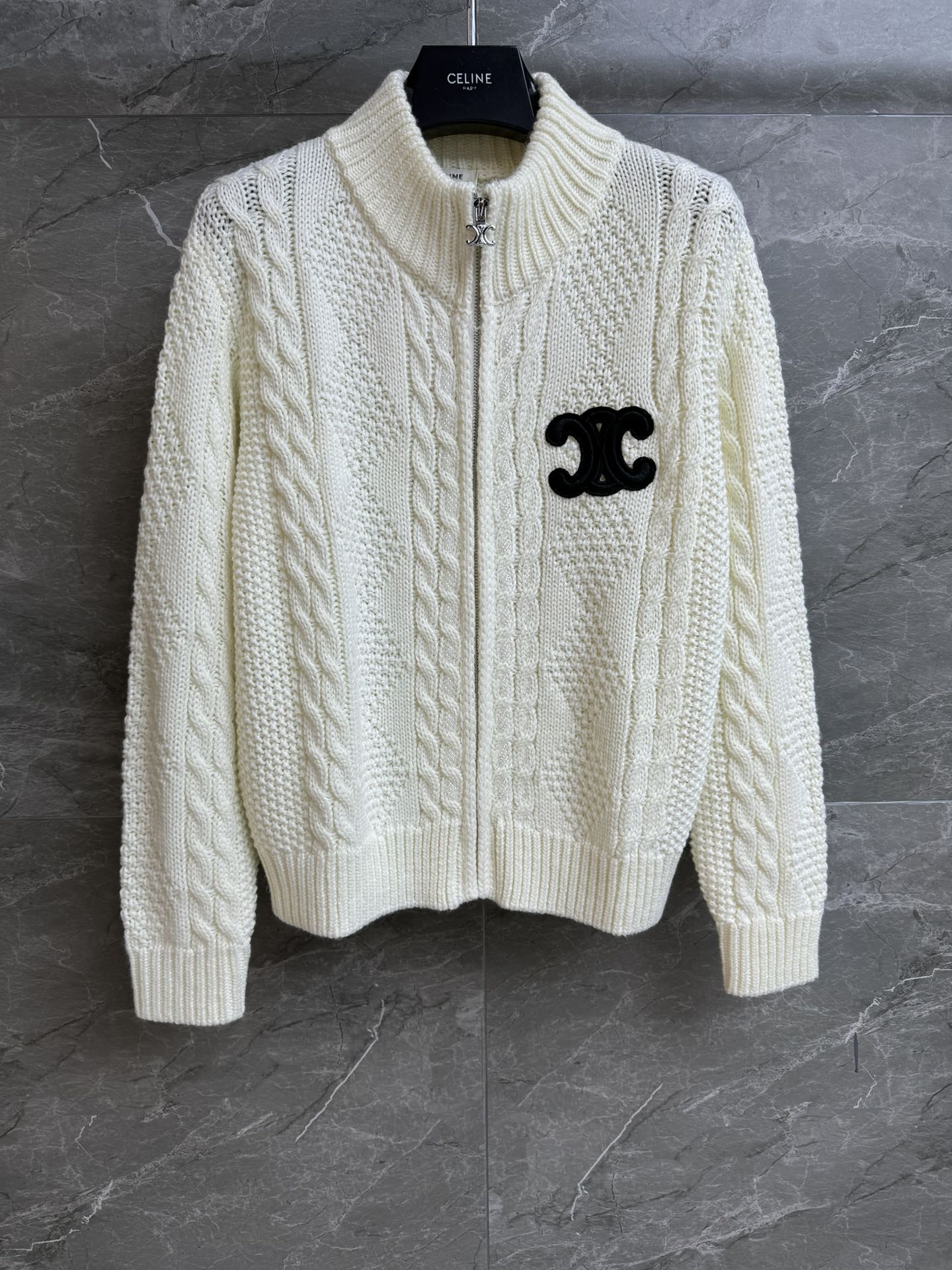 NO:664087,Autumn and winter new models have been shipped. CL stand-up collar twist cardigan 2025 autumn and winter series. Stand-up collar zipper design. Arc de Triomphe embroidered badge decoration. Hand-beaded embellishment. Twist woven texture. Exquisite and lazy. Wool knitted fabric. Comfortable and skin-friendly. Loose fit. The upper body is slim and versatile. Complete trademarks. Sizes SML,, 19860909秋冬新款出货啦 CL立领麻花开衫 2025秋冬系列 立领拉链设计 凯旋门刺绣徽章装饰 手工串珠点缀 麻花编织纹理 精致慵懒 羊毛针织面料 舒适亲肤 宽松版型 上身显瘦又百搭 商标齐全 尺码SML,, ,Women's clothing