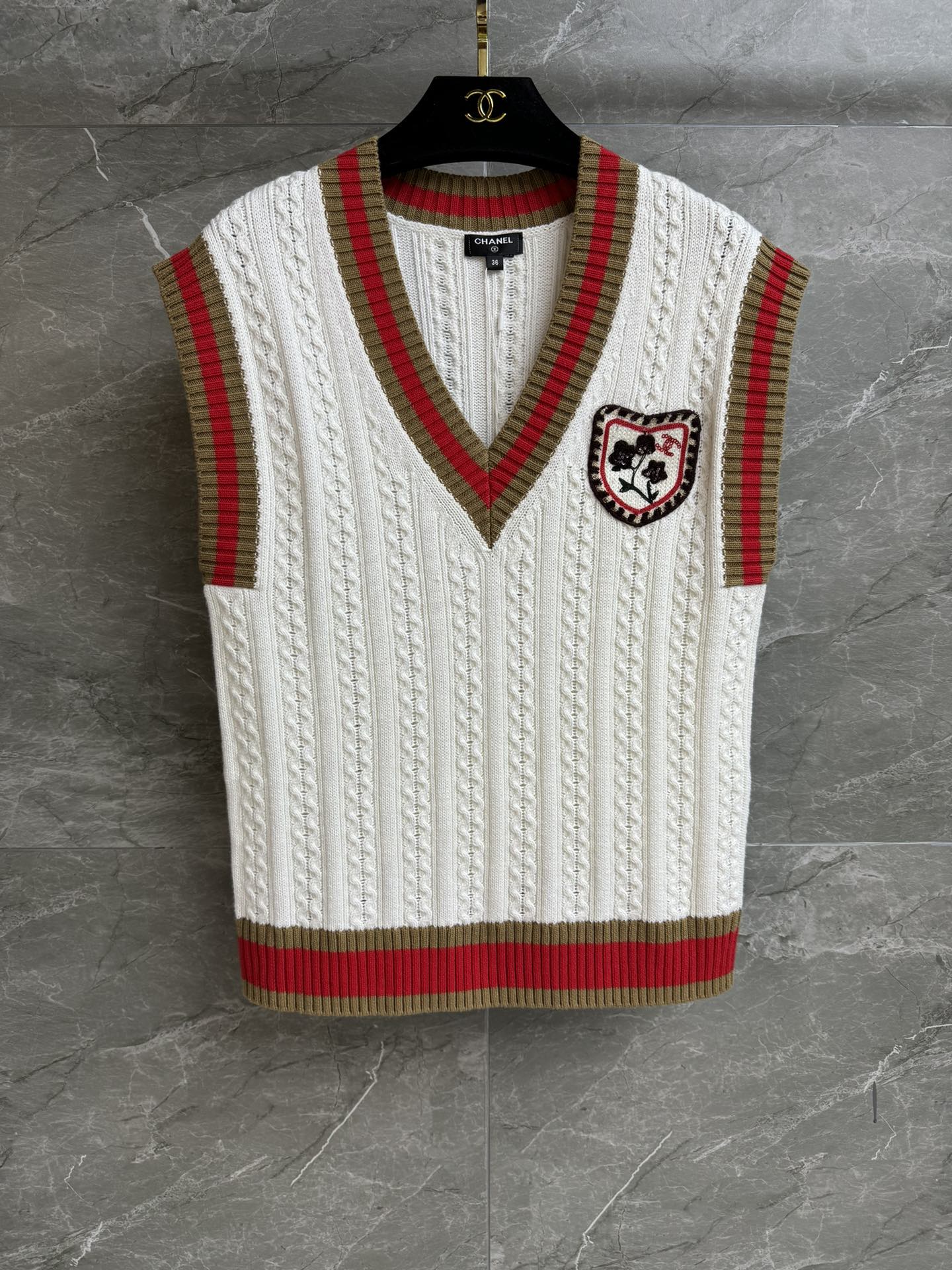 NO:666755,The high version has been shipped. Xiangjia badge college style vest 2026 early spring series. Temperament V-neck design. Exquisite embroidery badge embellishment. Contrast stripe splicing. Twist woven texture. Casual and fashionable to reduce age. Cashmere and cotton blended knitted fabric. Soft, comfortable and skin-friendly. Normal fit. Upper body looks slim and elegant. Complete trademarks. Comes with cloth bag. Sizes SML, Chanel, Alexander Wang19860909高版本出货啦 香家徽章学院风背心 2026早春系列 气质V领设计 精致刺绣徽章点缀 撞色条纹拼接 麻花编织纹理 休闲时髦减龄 羊绒棉混纺针织面料 柔软舒适亲肤 正常版型 上身显瘦又气质 商标齐全 配有布袋 尺码SML,,chanel, ,Women's clothing