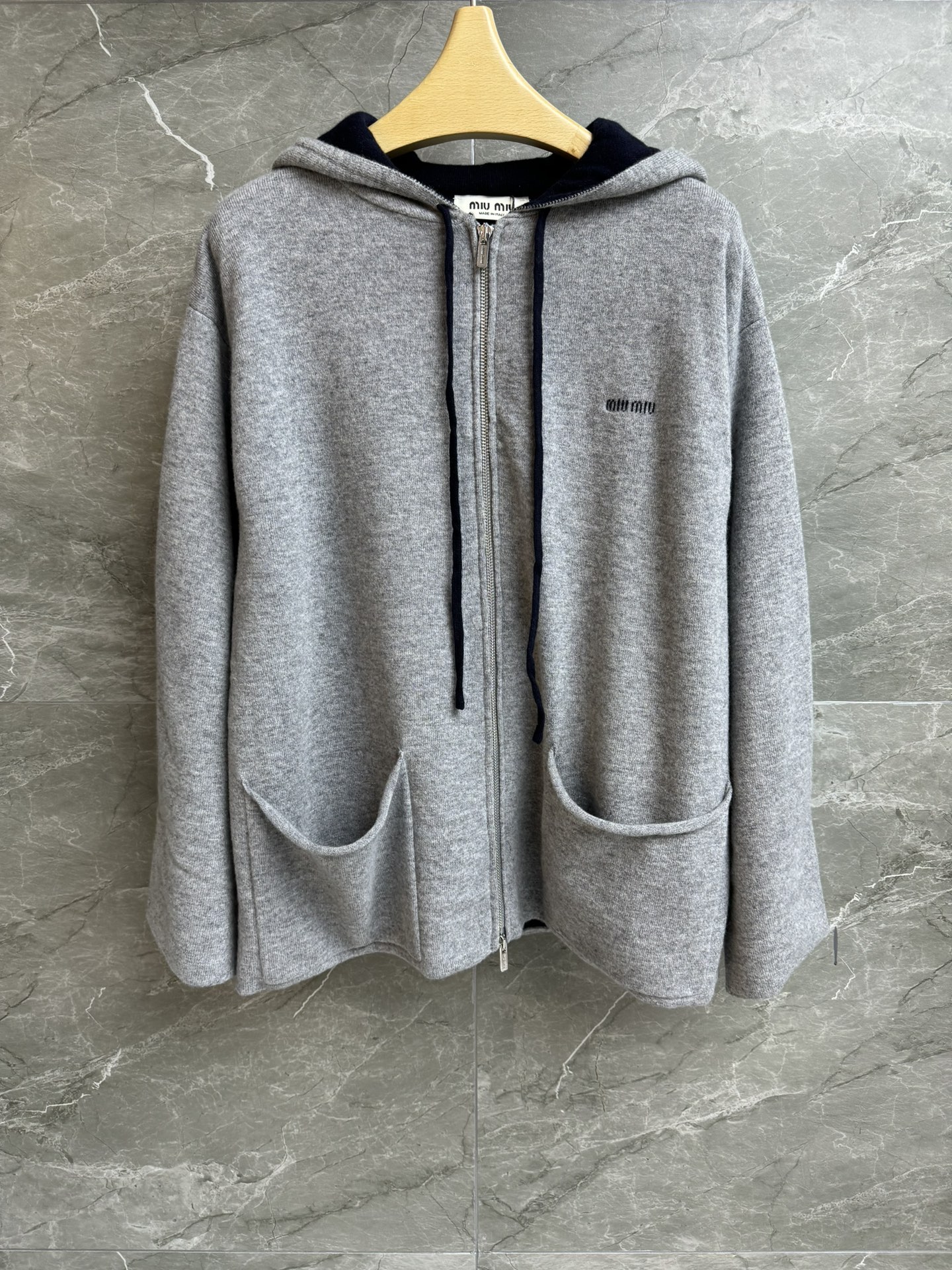 NO:697663,New arrival for early spring. Miu gray hooded cashmere cardigan. 2026 early spring series. Hooded neckline. Double zipper design. Letter logo intarsia pattern embellishment. Gray and blue color matching. High-end fashion. Cashmere knitted fabric. Loose fit. The upper body is lazy and casual. Complete trademarks. Sizes: smL,,miumiu,hats,19860909早春新款上新啦 Miu灰色连帽羊绒开衫 2026早春系列 连帽领口 双开拉链设计 字母logo嵌花图案点缀 灰蓝配色高级时髦 羊绒针织面料 宽松版型 上身慵懒随意 商标齐全 尺码smL,,miumiu,hats,,Women's clothing