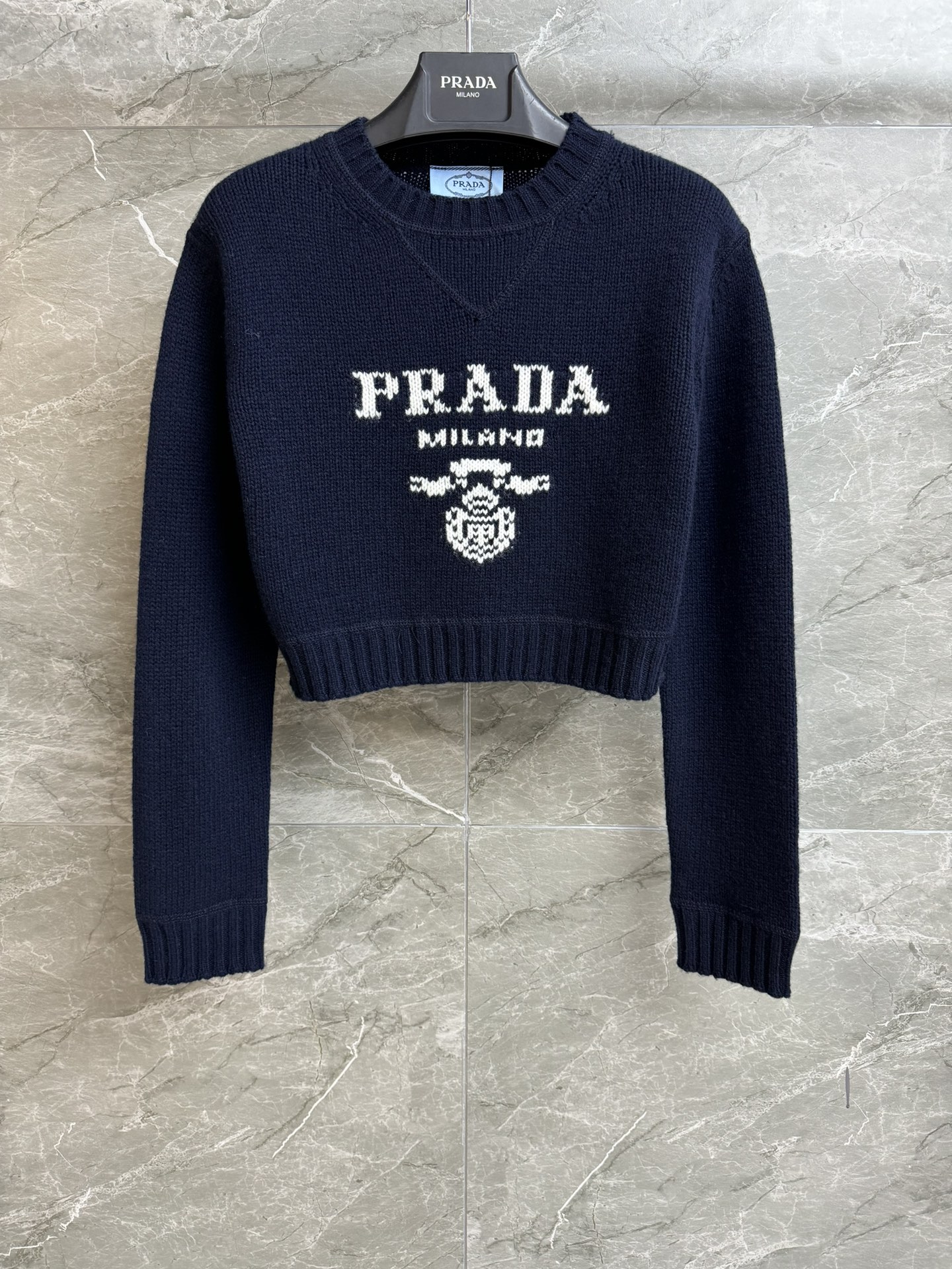 NO:715529,The high version has been shipped. P's navy blue short sweater 2025 autumn and winter series. Round neck design. Contrast intarsia logo pattern. Highly recognizable. Simple and high-end. Wool and cashmere blended fabric. Soft, comfortable and textured. Short version. The upper body is slim and fashionable. Complete trademarks. Sizes SML,,sweaters,19860909高版本出货啦 P家藏青色短款毛衣 2025秋冬系列 圆领领口设计 撞色嵌花logo徽标图案 辨识度极高 简约又高级 羊毛羊绒混纺面料 软糯舒适有质感 短款版型 上身显瘦又时髦 商标齐全 尺码SML,,sweaters,,Women's clothing