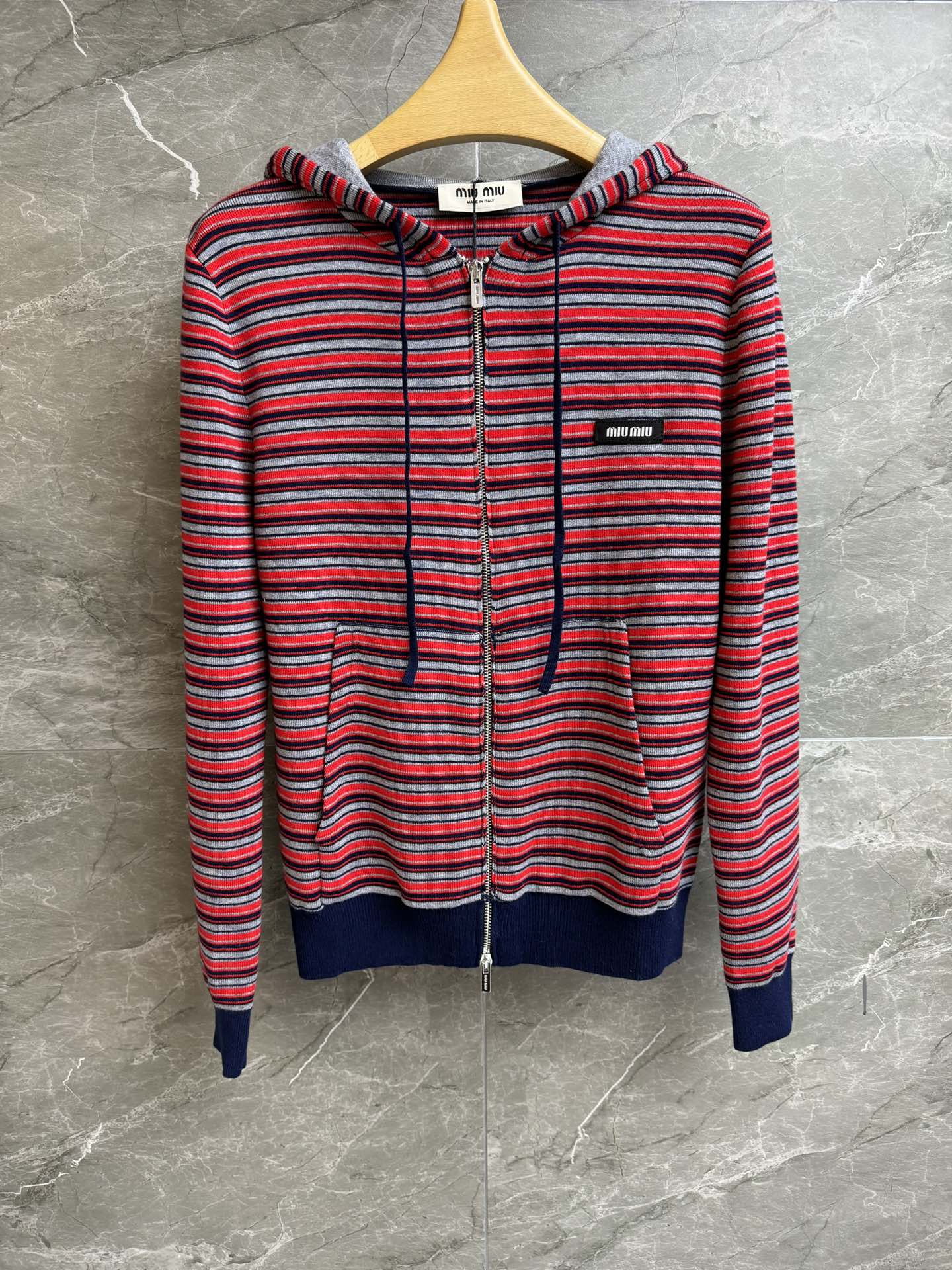 NO:717310,New arrival for early spring. Miu red striped cardigan 2026 early spring series. Hooded zipper design. Patch letter logo embroidery embellishment. Red, gray and blue stripes contrasting colors. Retro and fashionable. Customized knitted fabric. Comfortable and skin-friendly. Normal fit. The upper body is slim and versatile. Complete trademarks. Sizes SML,,miumiu,hats,19860909早春新款上新啦 Miu红色条纹开衫 2026早春系列 连帽拉链设计 贴布字母logo刺绣点缀 红灰蓝条纹撞色 复古时髦 定制针织面料 舒适亲肤 正常版型 上身显瘦又百搭 商标齐全 尺码SML,,miumiu,hats,,Women's clothing