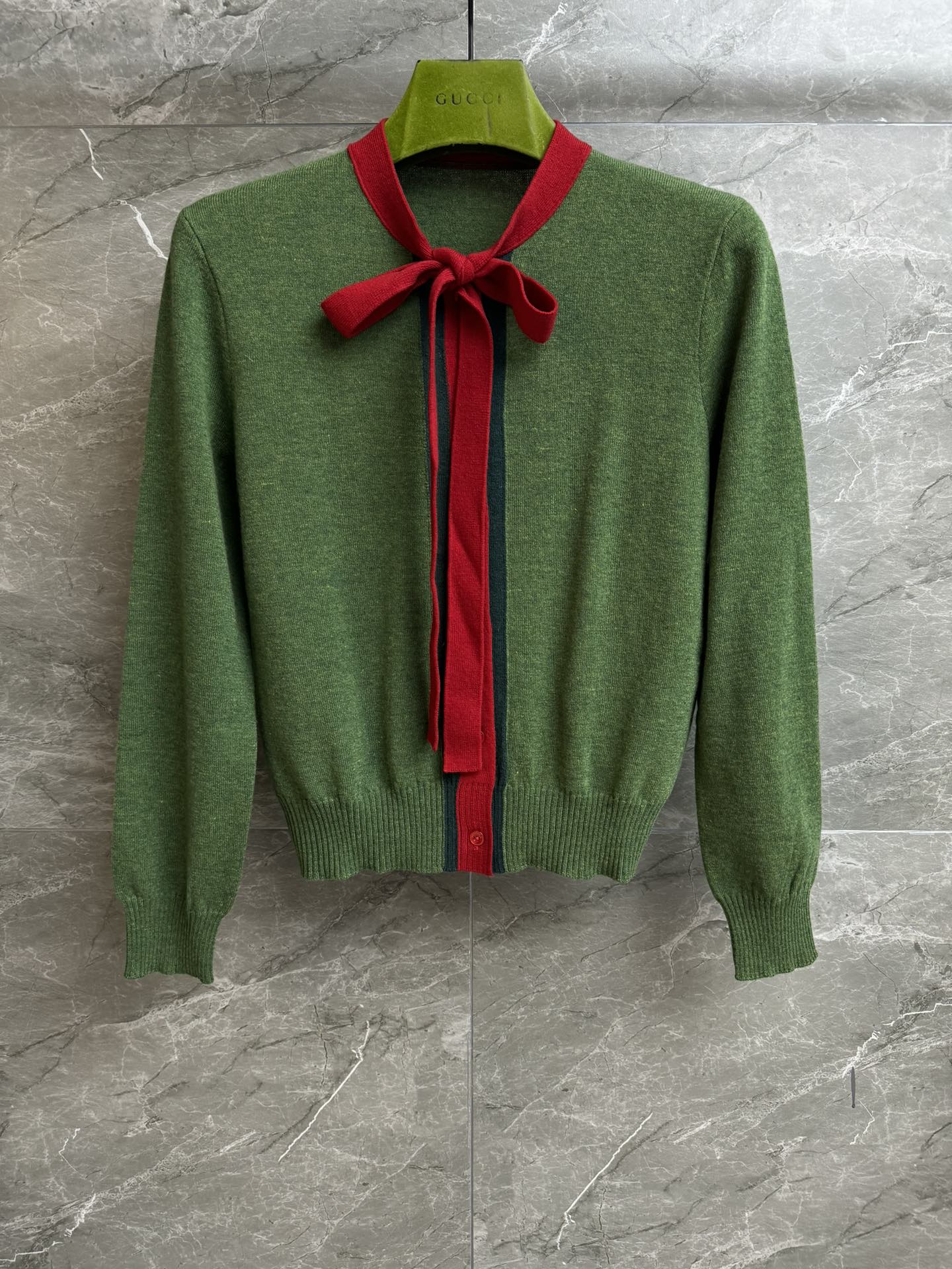 NO:735596,The new model for early spring has been shipped. G family bow knitted cardigan 2026 early spring series. Bow tie neckline. Contrast color splicing design. Red and green webbing intarsia decoration. Exquisite, fashionable and age-reducing. Wool and cashmere knitted fabric. Soft and comfortable. Slim fit. The upper body is slim and elegant. Complete trademarks. Sizes SML,,gucci,19860909早春新款出货啦 G家蝴蝶结针织开衫 2026早春系列 蝴蝶结系带领口 撞色拼接设计 红绿织带嵌花装饰 精致时髦减龄 羊毛羊绒针织面料 柔软舒适 修身版型 上身显瘦又气质 商标齐全 尺码SML,,gucci,,Women's clothing