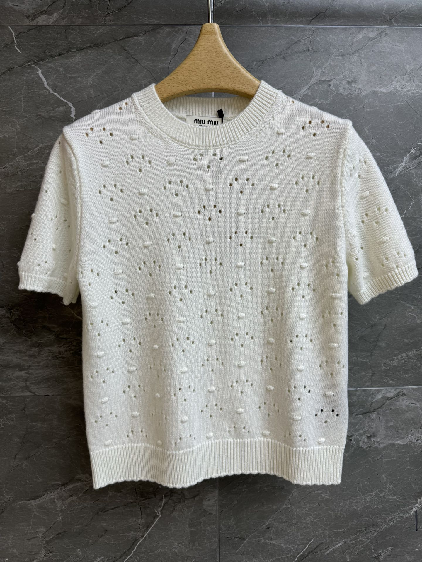 NO:752244,New model for early spring has been shipped. Miu white hollow short sleeves 2026 early spring series. Round ribbed neckline. Logo embellishment on the back. Unique hollow hole craftsmanship. Fashionable and age-reducing. Wool knitted fabric. Light and comfortable. Normal fit. The upper body is slim and elegant. Complete trademarks. Sizes SML, miumiu, T-shirt,19860909早春新款出货啦 Miu白色镂空短袖 2026早春系列 圆领罗纹领口 后背logo徽标点缀 别致的镂空挑孔工艺 时髦减龄 羊毛针织面料 轻薄舒适 正常版型 上身显瘦又气质 商标齐全 尺码SML,,miumiu,T-shirt,,Women's clothing