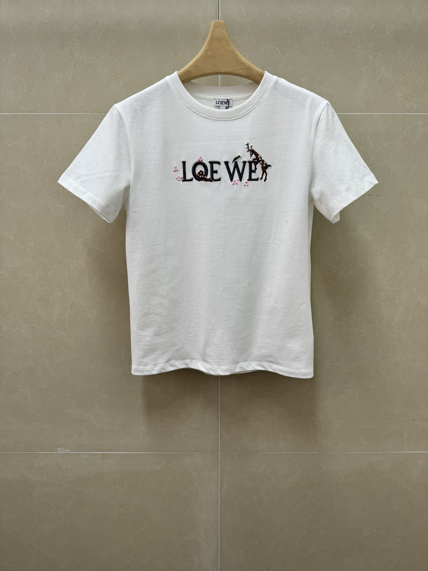 NO:797181,The new style for early spring is new. Loewe embroidered deer T-shirt 2026 spring and summer series. Round neck design. Logo embroidery on the chest outlines the childish deer pattern. Exquisite and fashionable to reduce age. Imported pure cotton fabric. Comfortable and skin-friendly. Slim fit. The upper body is slim and elegant. Sizes SML, loewe, tees, t-shirt,19860909早春新款上新啦 罗意威刺绣小鹿T恤 2026春夏系列 圆领领口设计 胸前logo徽标刺绣工艺 勾勒出小鹿童趣图案 精致时髦减龄 进口纯棉面料 舒适亲肤 修身版型 上身显瘦又气质 尺码SML,,loewe,tees，t-shirt,,Women's clothing