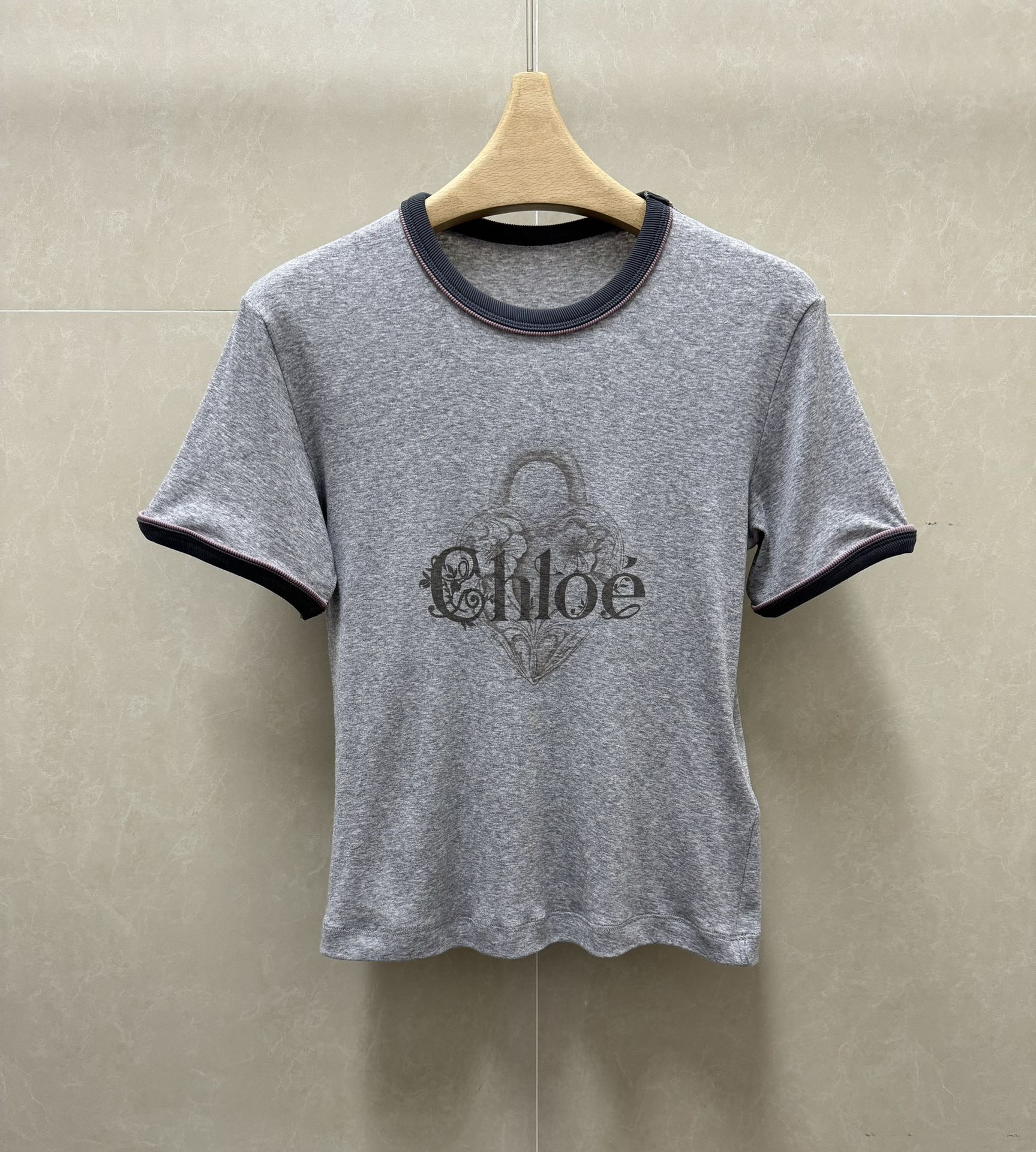 NO:798697,New arrival for early spring. Chloe gray printed T-shirt 2026 spring and summer series. Round neck contrasting neckline design. Lock bag printed pattern. Classic letter logo embellishment. Imported pure cotton fabric. Comfortable, skin-friendly and breathable. Slim fit. The upper body is slim and versatile. Sizes SML, chloe, loewe, tees, t-shirt,19860909早春新款上新啦 Chloe灰色印花T恤 2026春夏系列 圆领撞色领口设计 采用锁头包印花图案 经典字母logo点缀 进口纯棉面料 舒适亲肤透气 修身版型 上身显瘦又百搭 尺码SML,,chloe,loewe,tees，t-shirt,,Women's clothing