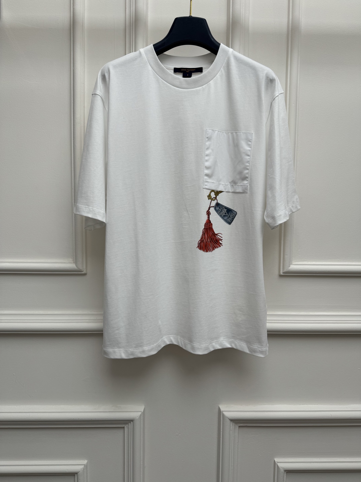 NO:834814,New arrival in early spring. L Family Pocket Keychain T-shirt 2026 Spring and Summer Series. Round neck design. Red tassel on chest pocket + metal keychain printed pattern. Multi-element retro. Full of artistic sense. Fashionable personality. Imported pure cotton fabric. Comfortable, skin-friendly and breathable. Loose fit. The upper body is slim and versatile. Sizes are SML, Louis Vuitton, tees, t-shirt, keychain,19860909早春新款上新啦 L家口袋钥匙扣T恤 2026春夏系列 圆领领口设计 胸前口袋红色流苏+金属钥匙扣印花图案 多元素复古 艺术感满满 时髦个性 进口纯棉面料 舒适亲肤透气 宽松版型 上身显瘦又百搭 尺码SML,,louis vuitton,tees，t-shirt,keychain,,Women's clothing