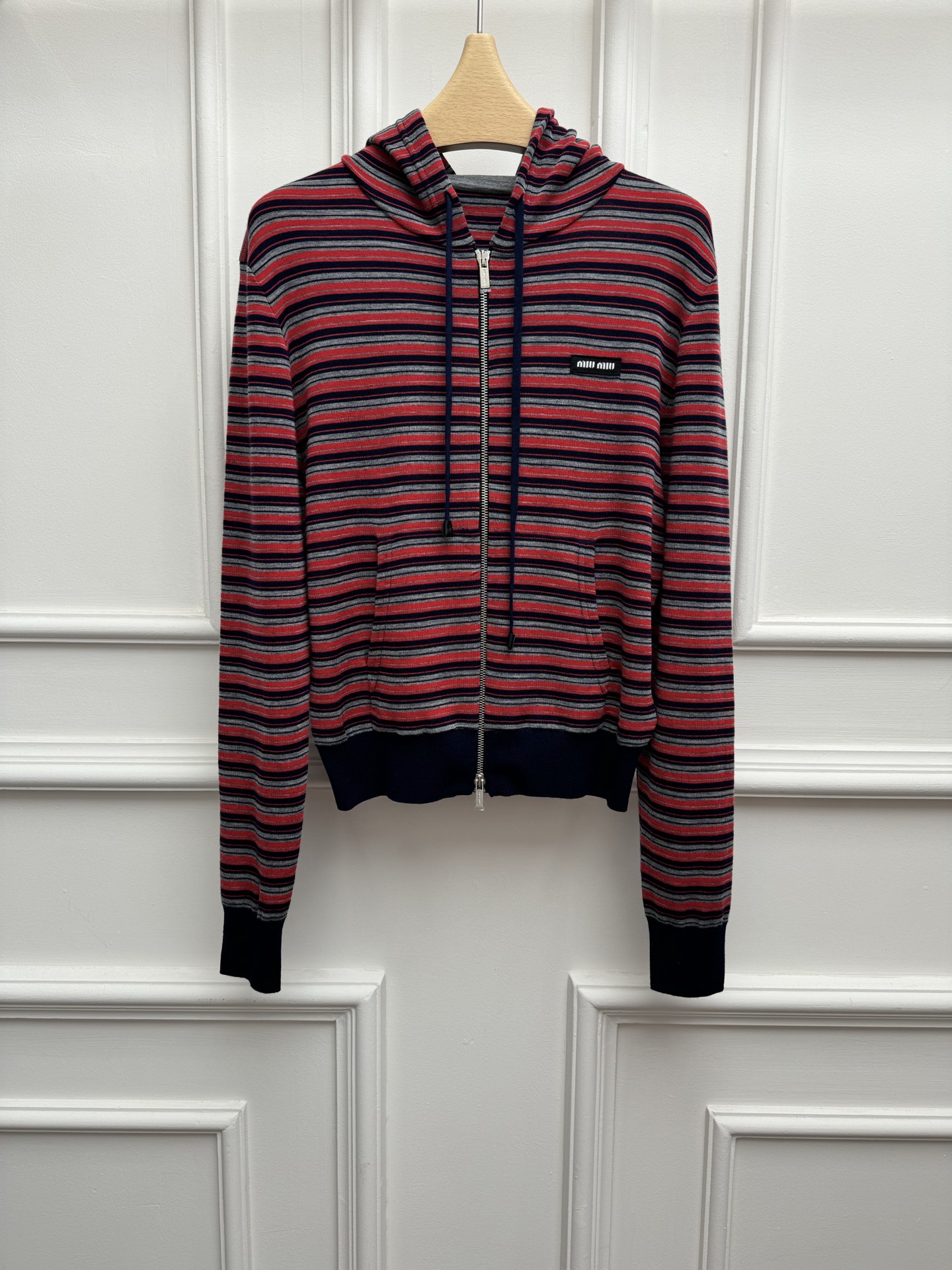 NO:837631,The high version is out. Miu red striped cardigan 2026 early spring series. Hooded zipper design. Patch letter logo embroidery embellishment. Red, gray and blue stripe contrast. Retro and fashionable. Customized wool fabric. Comfortable and skin-friendly. Normal fit. The upper body is slim and versatile. Complete trademarks. Sizes SML,,miumiu,hats,19860909高版本出货啦 Miu红色条纹开衫 2026早春系列 连帽拉链设计 贴布字母logo刺绣点缀 红灰蓝条纹撞色 复古时髦 定制羊毛面料 舒适亲肤 正常版型 上身显瘦又百搭 商标齐全 尺码SML,,miumiu,hats,,Women's clothing