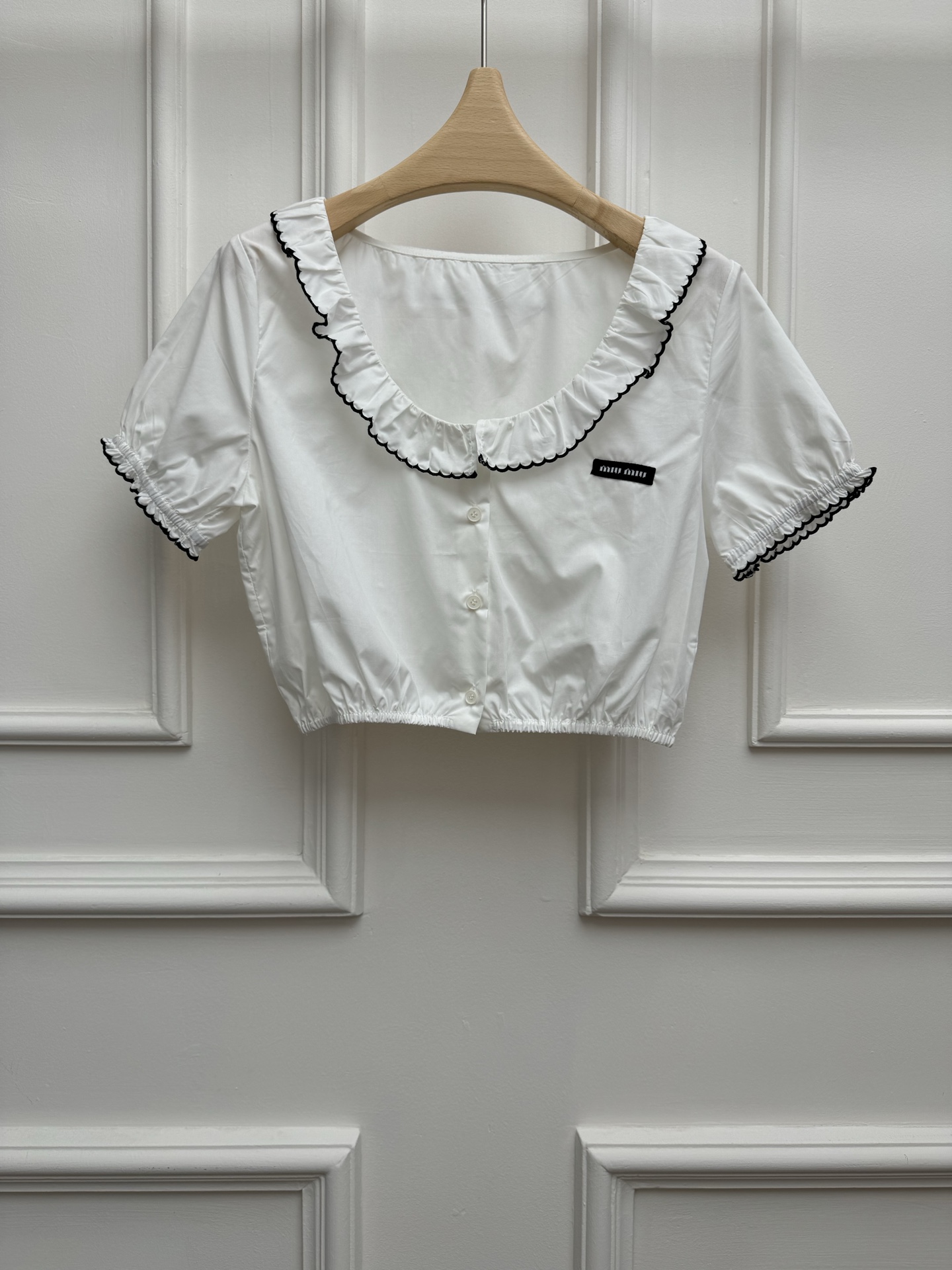 NO:840077,New spring and summer new styles Miu lace short shirt 2026 spring and summer series Square neck neck design Black edge wavy wood ear trim Embroidered logo on the chest Sweet and fashionable to reduce age Customized cotton poplin material Comfortable and skin-friendly Short version The upper body is slim and elegant Size SML,,miumiu,shirts,19860909春夏新款上新啦 Miu花边短款衬衫 2026春夏系列 方领领口设计 黑边波浪木耳边装饰 胸前徽标刺绣logo点缀 甜美时髦减龄 定制棉府绸材质 舒适亲肤 短款版型 上身显瘦又气质 尺码SML,,miumiu,shirts,,Women's clothing