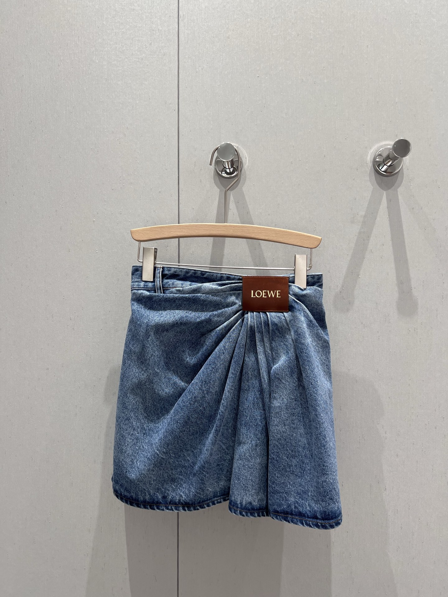 NO:327556,Loew* 25Ss Spring and Summer New Style Irregular Wrinkled Leather Brand Pure Cotton Denim Skirt | Exclusive YB Development!  High-end production!  The jeans poem of pleated art, the brand logo engraved on the waist leather brand extends downwards, spreading out three-dimensional pleats layer by layer on the pure cotton fabric of denim blue like waves. The novel tailoring techniques break the monotonous impression of traditional denim skirts and give the skirt a sense of flowing rhythm. The A-line skirt hem outlines the silhouette with precise stitching, and the wrinkled details swing lightly with the pace. The high-waist design cleverly lengthens the proportion of the legs, while the natural texture of the pure cotton denim maintains a comfortable wearing experience. This is a design item that perfectly integrates craftsmanship and creativity - daily matching knitted tops show casualness, and leather items instantly enhance the tension of the shape. The three-dimensional sense of pleated and the toughness of the denim are here to achieve a unique statement piece. S/M/L is available in stock, loewe, skirts, alexander wang19860909Loew* 25Ss春夏新款 不规则褶皱皮牌纯棉牛仔半裙丨独家yb开发！高版出品！褶皱艺术的牛仔诗篇,腰间皮牌镌刻的品牌标识,向下延伸出立体褶皱,如海浪般在牛仔蓝的纯棉面料上层层展开.新颖的剪裁手法打破传统牛仔裙的单调印象,赋予裙身流动的韵律感.A字裙摆以精确的车缝线勾勒廓形,褶皱细节随步伐轻盈摆动.高腰设计巧妙拉长腿部比例,而纯棉牛仔的天然肌理则保持着舒适的穿着体验.这是件将工艺与创意完美融合的设计单品——日常搭配针织上衣尽显随性,配以皮质单品则瞬间提升造型张力.褶皱的立体感与牛仔的硬朗在此达成精妙平衡,成就与众不同的statement piece.现货发售S/M/L,,loewe,skirts,alexander wang,Women's clothing