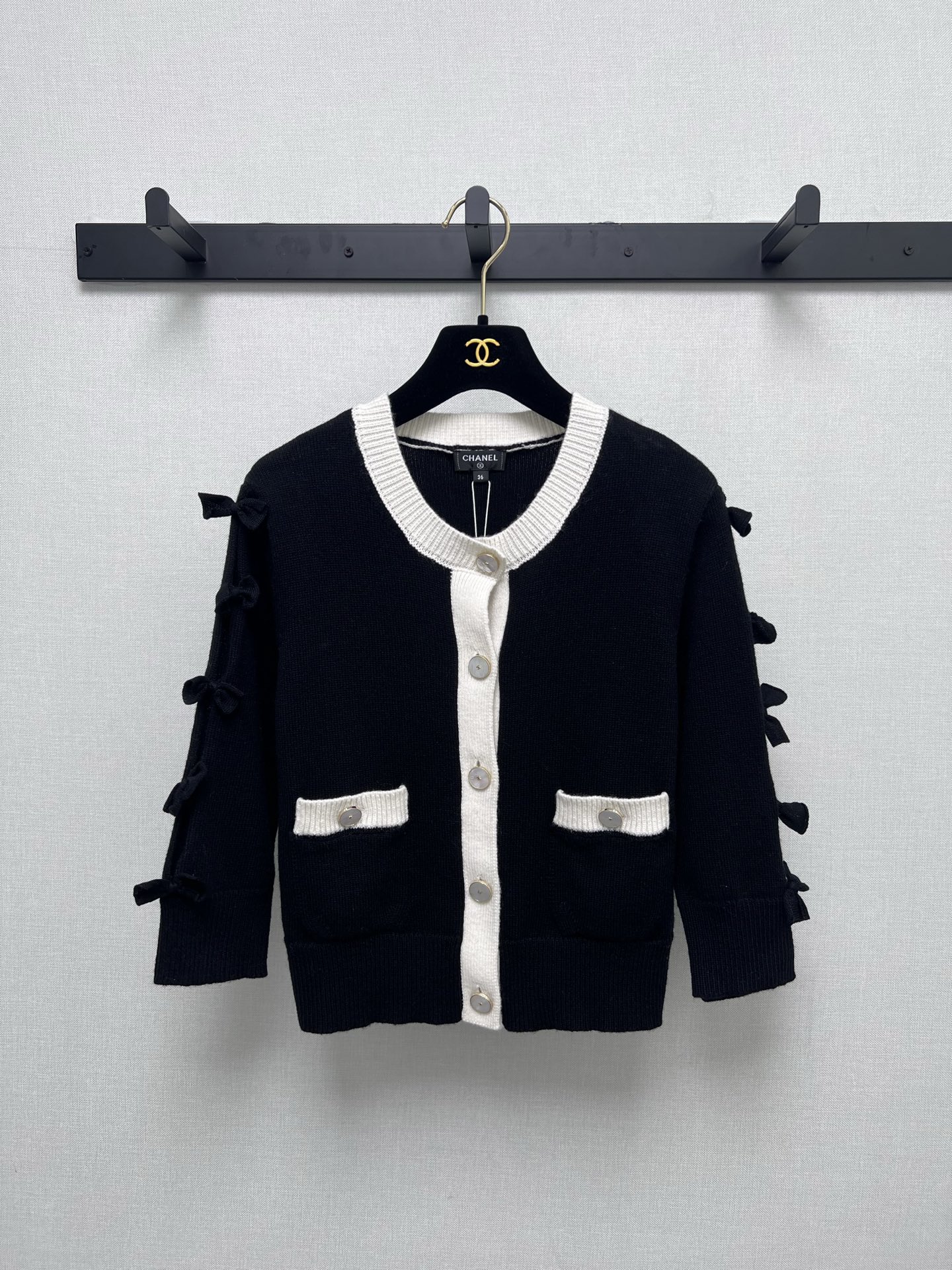 NO:506874,Supports the replacement of Xiaoxiang CHAN**LFW premium handicraft workshop series // Top version of wool knitted cardigans, the first batch of individual black and white colors as classic themes, exquisite wool blended knitted fabric, soft and high-end texture. 1:1 open mold making metal buckles, each button is inlaid with an iconic double C logo, showing the brand's luxury. One side of the wool is decorated with exquisite white bows, adding a bit of sweetness and agility to the whole. It is matched with a practical pocket design, so this cardigan is functional in elegance, white is sweet and elegant, and black is classic and unique. Two colors can be used to take real photos, chanel, alexander wang19860909支持换款小香CHAN**LFW高级手工坊系列//羊毛针织开衫顶级版本,首批单独家发黑白配色作为经典主题,精羊毛混纺针织面料,质感柔软且高级.1:1开模制作金属扣、每颗纽扣上都镶嵌着标志性的双C标识,尽显品牌奢华感.衣身一侧点缀着精致的白色蝴蝶结,为整体增添了几分甜美与灵动,搭配实用的口袋设计,让这件开衫在优雅中兼具功能性,白色款甜美优雅,黑色款经典别致.两色可入实拍细节图,,chanel,alexander wang,Women's clothing