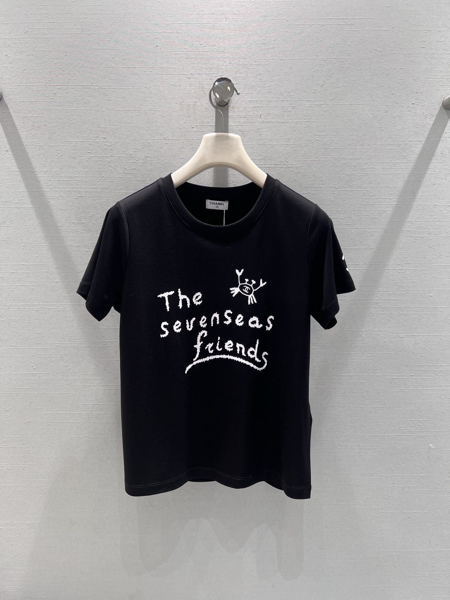 NO:666843,Support exchange Chan*L 2026SS early spring new product series // The hand-painted lettering short-sleeved T-shirt on the chest has a hand-painted text pattern with small cartoon elements. The brushstrokes are smart and playful, breaking the monotony of the solid color T-shirt and adding a lively artistic atmosphere to the whole; the cuffs are embellished with the classic double C logo, and the details are exquisite, full of childlike fun and French elegance~SML real shot details,,chanel,T-shirt,tees,t-shirt, 19860909支持换款Chan*L 2026SS早春新品系列//手绘字母短袖T恤胸前的手绘风文字图案搭配卡通小元素,笔触灵动俏皮,打破了纯色T恤的单调感,为整体增添了活泼的艺术氛围；袖口处点缀经典的双C标识,细节处尽显精致,充满童趣和法式优雅气息～SML实拍细节,,chanel,T-shirt,tees，t-shirt, ,Women's clothing