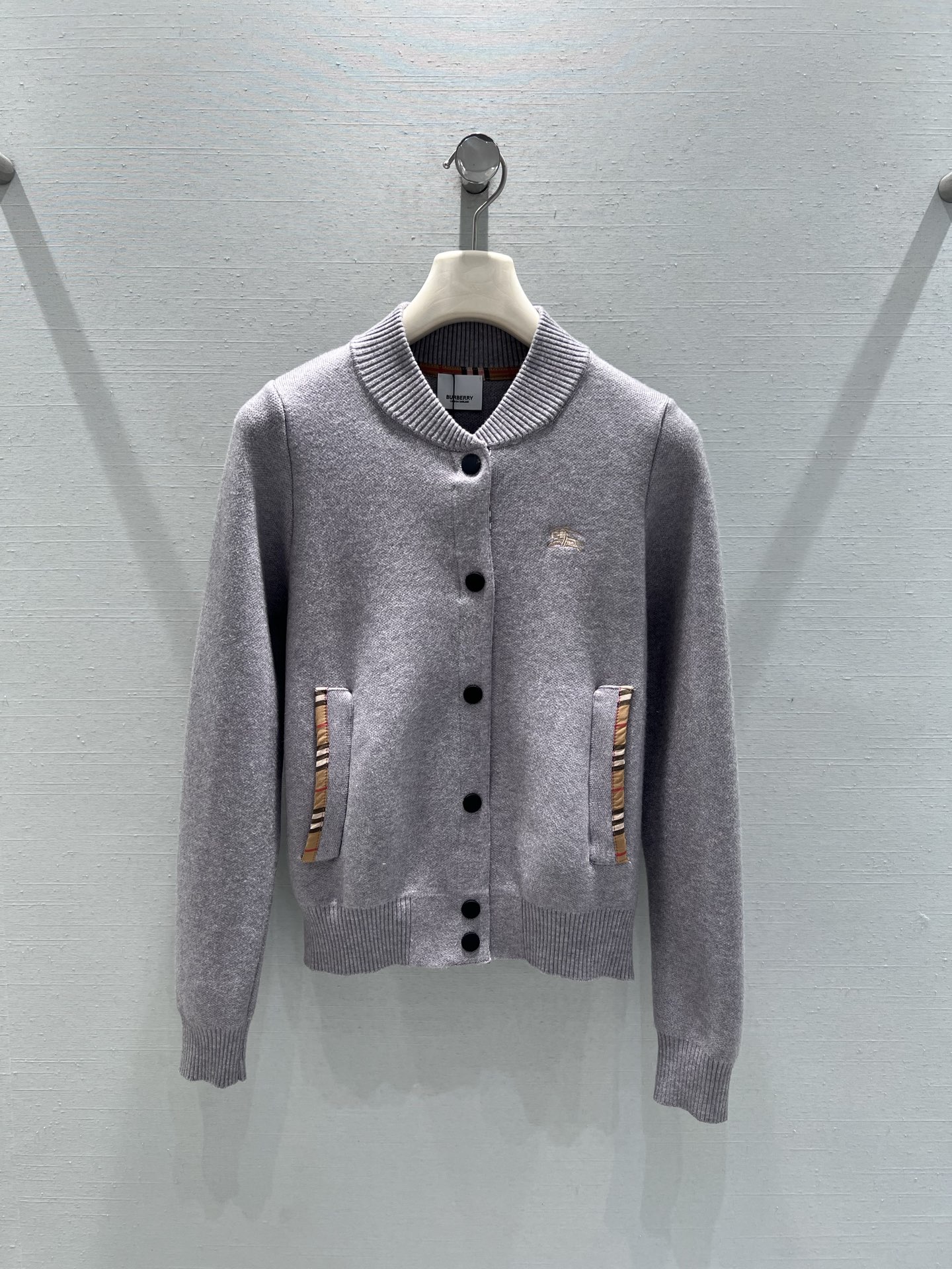 NO:683723,Support Burber*y26SS early spring new product series // Plaid knitted cardigan stand-up collar baseball collar version, single-row black button closure, short cut, high-density knitted fabric, thick and soft texture. The chest is embellished with the classic equestrian knight embroidery logo; the edges of the pockets on both sides are spliced ​​with BBR plaid fabric, echoing the plaid lining on the inside of the collar, and the contrasting color design in the details makes the overall design more sense. SML real shot details,, burberry,19860909支持换款Burber*y26SS早春新品系列//格纹针织开衫立领棒球领版型,单排黑色纽扣开合,短款剪裁,高密针织面料,质地厚实且柔软.胸前点缀经典马术骑士刺绣logo；两侧口袋边缘拼接BBR格纹布料,与领口内侧的格纹内衬相呼应,细节处的撞色设计,整体更具设计感.SML实拍细节,,burberry,,Women's clothing