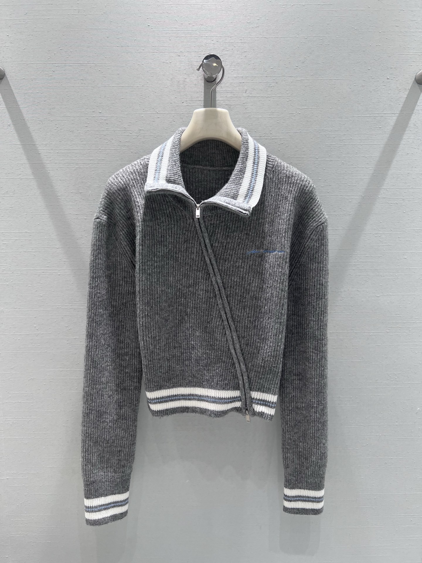 NO:686006,Support exchange AnnAndelma* 2026SS early spring new product series // Gray diagonal zipper knitted cardigan has an asymmetrical diagonal zipper design and a lapel shape, which is simple and individual. The body is made of vertical pit strip texture, which is more visually slimming. The high-end gray tones and white contrast stripes are embellished, adding a sense of casual vitality; the chest embroidery and edge hemming are exquisite, and the details highlight the workmanship. SML real shot details,,19860909支持换款 AnnAndelma*2026SS早春新品系列//灰斜拉链针织开衫不对称斜拉链设计,搭配翻领造型,自带简约又个性,衣身是竖坑条纹理,视觉上更显修身,高级灰调白色撞色条纹点缀,增添了休闲活力感；胸前刺绣,边缘包边工艺精致,细节处彰显做工.SML实拍细节,,,Women's clothing