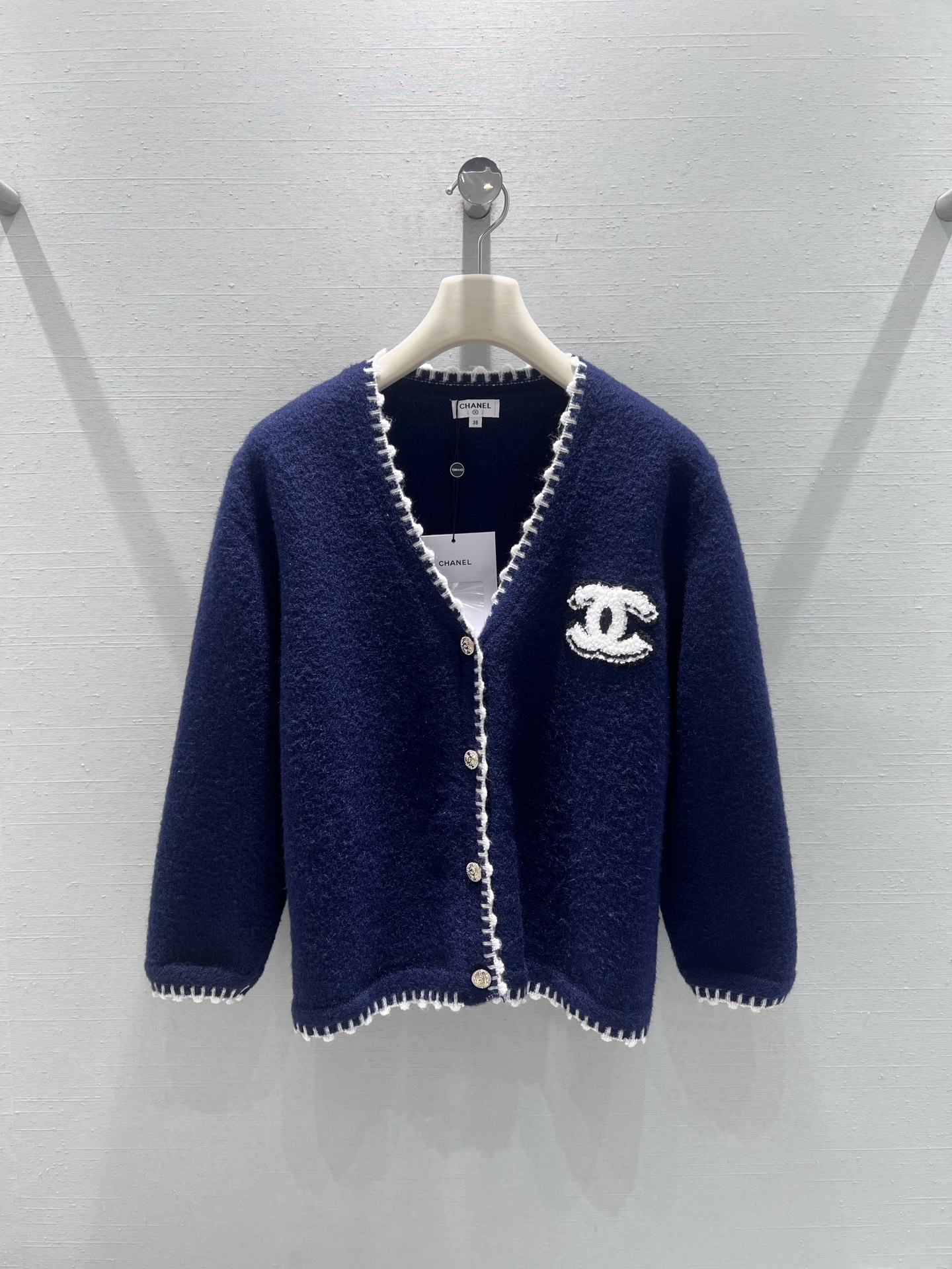 NO:694373,Support exchange Chan*L 2026SS early spring new product series // V-neck knitted sweater cardigan has a navy blue body, with white hand-stitching decoration on the edges. The sharp color contrast outlines a delicate fragrance outline. The cuffs, hem and placket are stitched in a unified way, with a full sense of detail. The chest is embroidered with a three-dimensional double C embroidery pattern, which has a thick texture and is full of French elegance. SML real shot details, chanel, sweaters,19860909支持换款Chan*L 2026SS早春新品系列//V领针织毛衣开衫藏青色衣身,边缘搭配白色手工缝线装饰,鲜明的色彩对比,勾勒出精致的香风轮廓,袖口、下摆与门襟的缝线工艺统一,细节感拉满；胸前缀有立体的双C刺绣图案,质感厚重,满满小香法式优雅气质.SML实拍细节,,chanel,sweaters,,Women's clothing